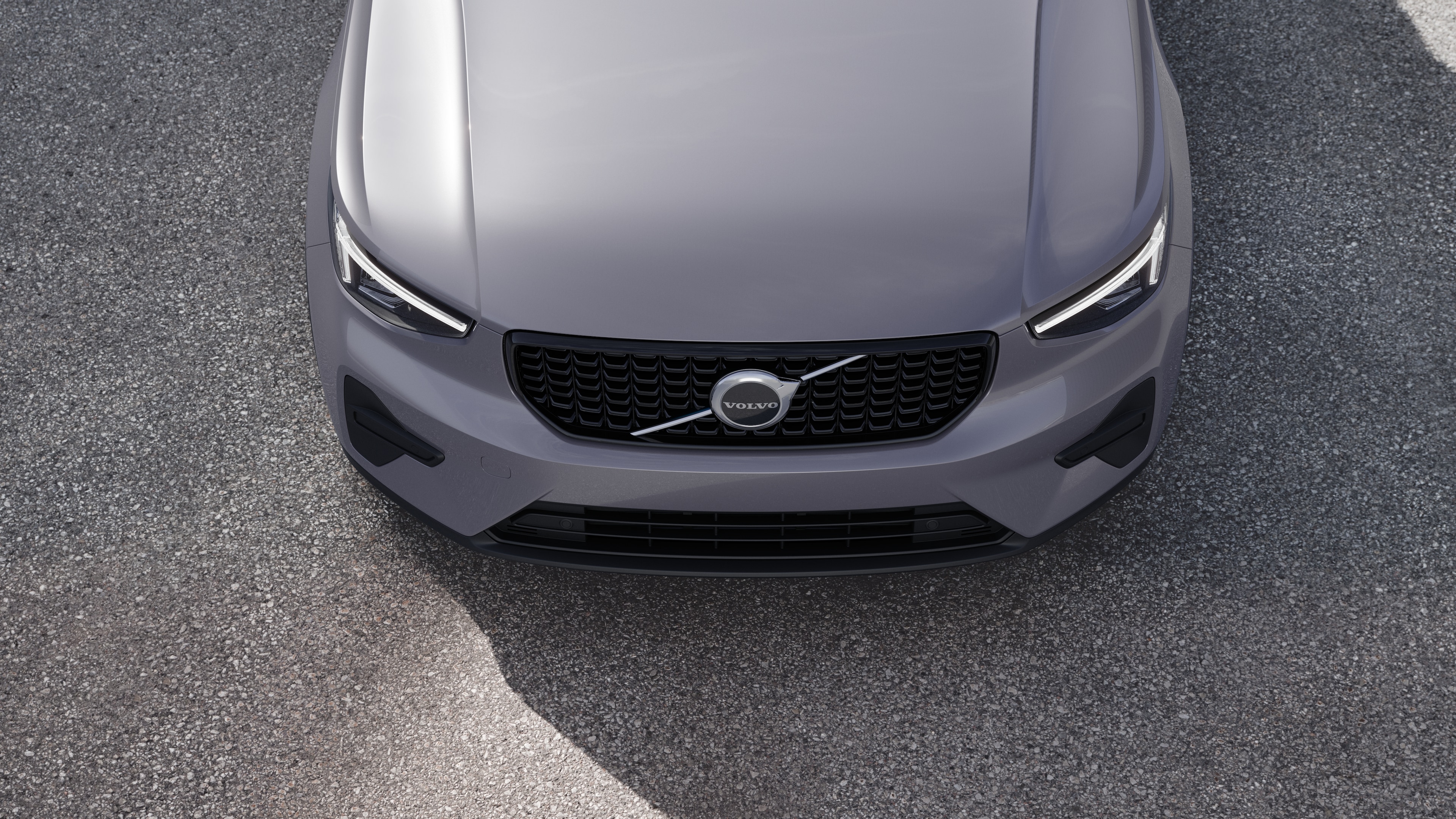 Volvo car exterior in three-quarter view on an urban street background, showing one side, roof, and part of the front.