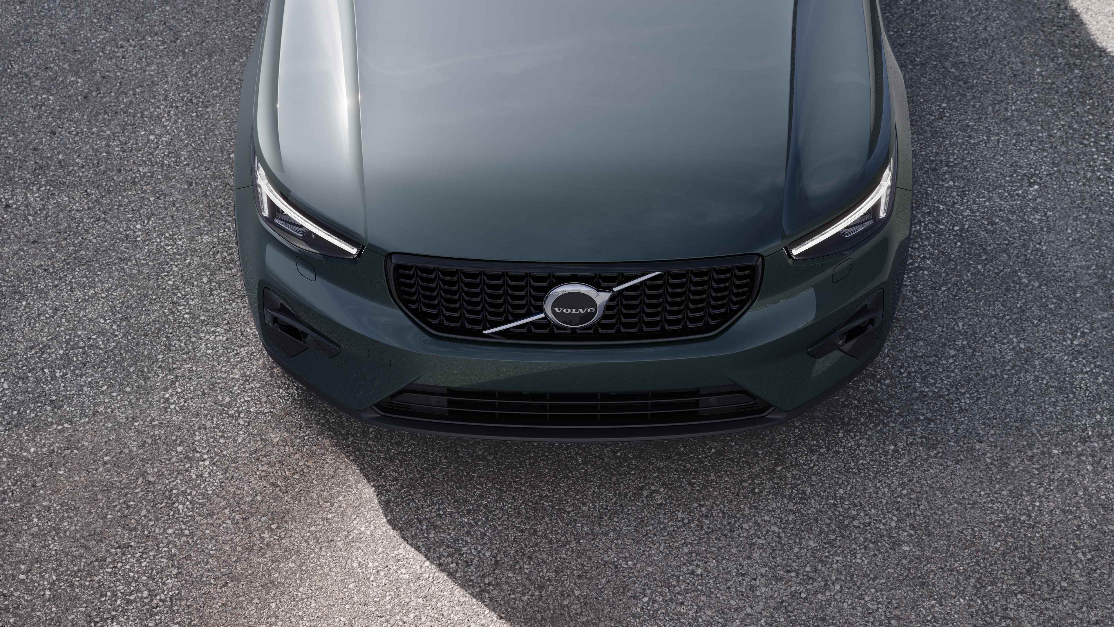 Volvobilens exteriör i trekvartsvy mot en urban gatubakgrund, som visar ena sidan, taket och en del av fronten.