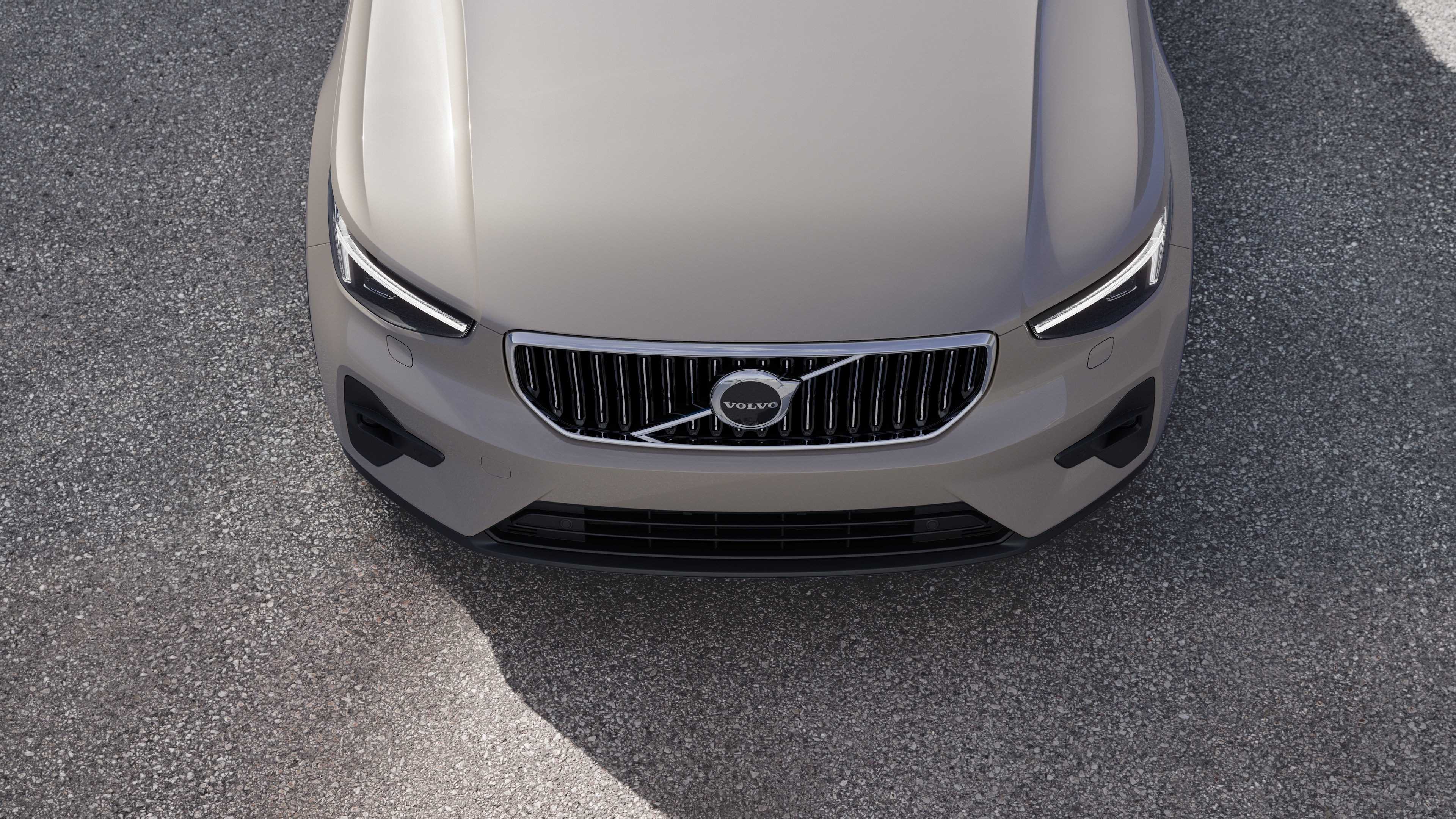 Volvo car exterior in three-quarter view on an urban street background, showing one side, roof, and part of the front.