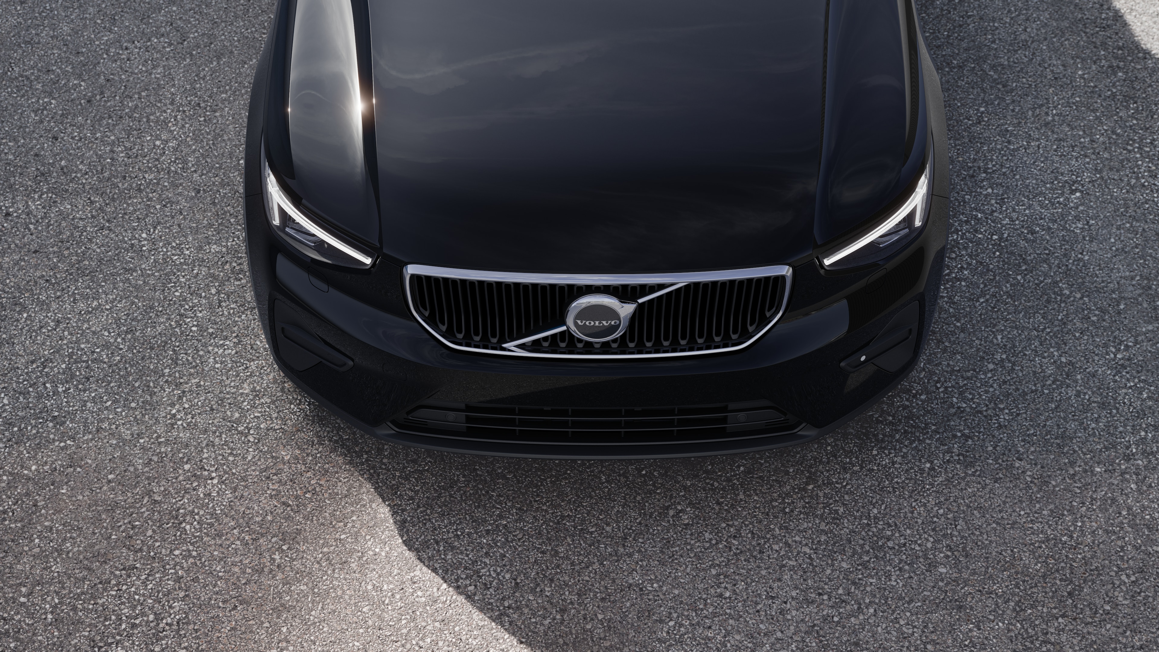 Volvobilens exteriör i trekvartsvy mot en urban gatubakgrund, som visar ena sidan, taket och en del av fronten.