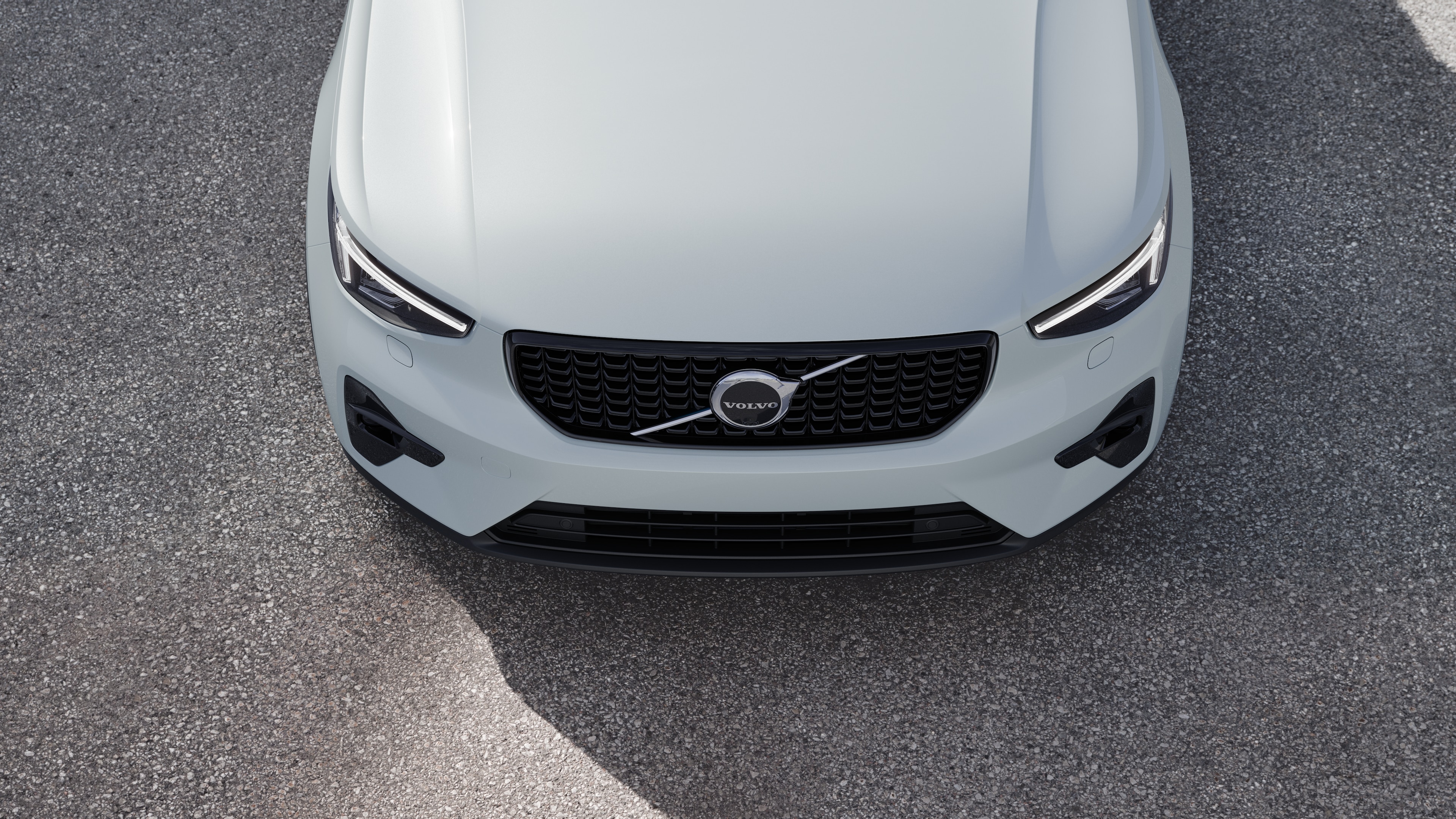 Volvobilens exteriör i trekvartsvy mot en urban gatubakgrund, som visar ena sidan, taket och en del av fronten.