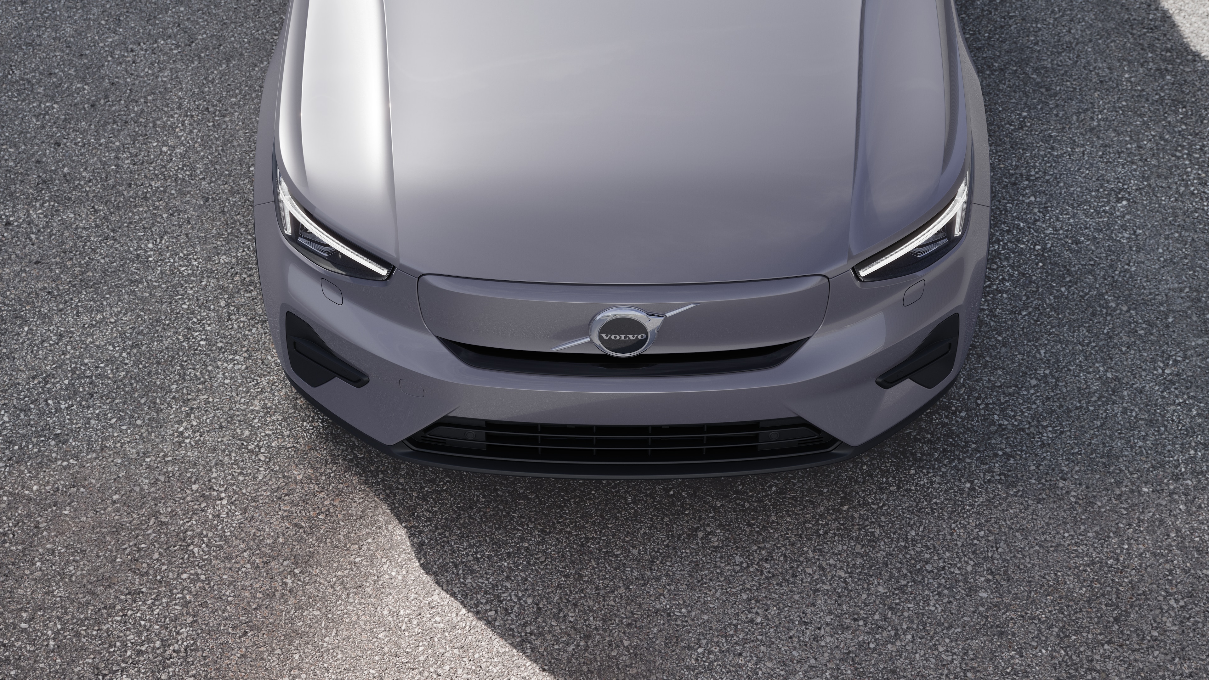 Volvo-bilens eksteriør i trekvartvisning på en bygadebaggrund, der viser den ene side, taget og en del af fronten.