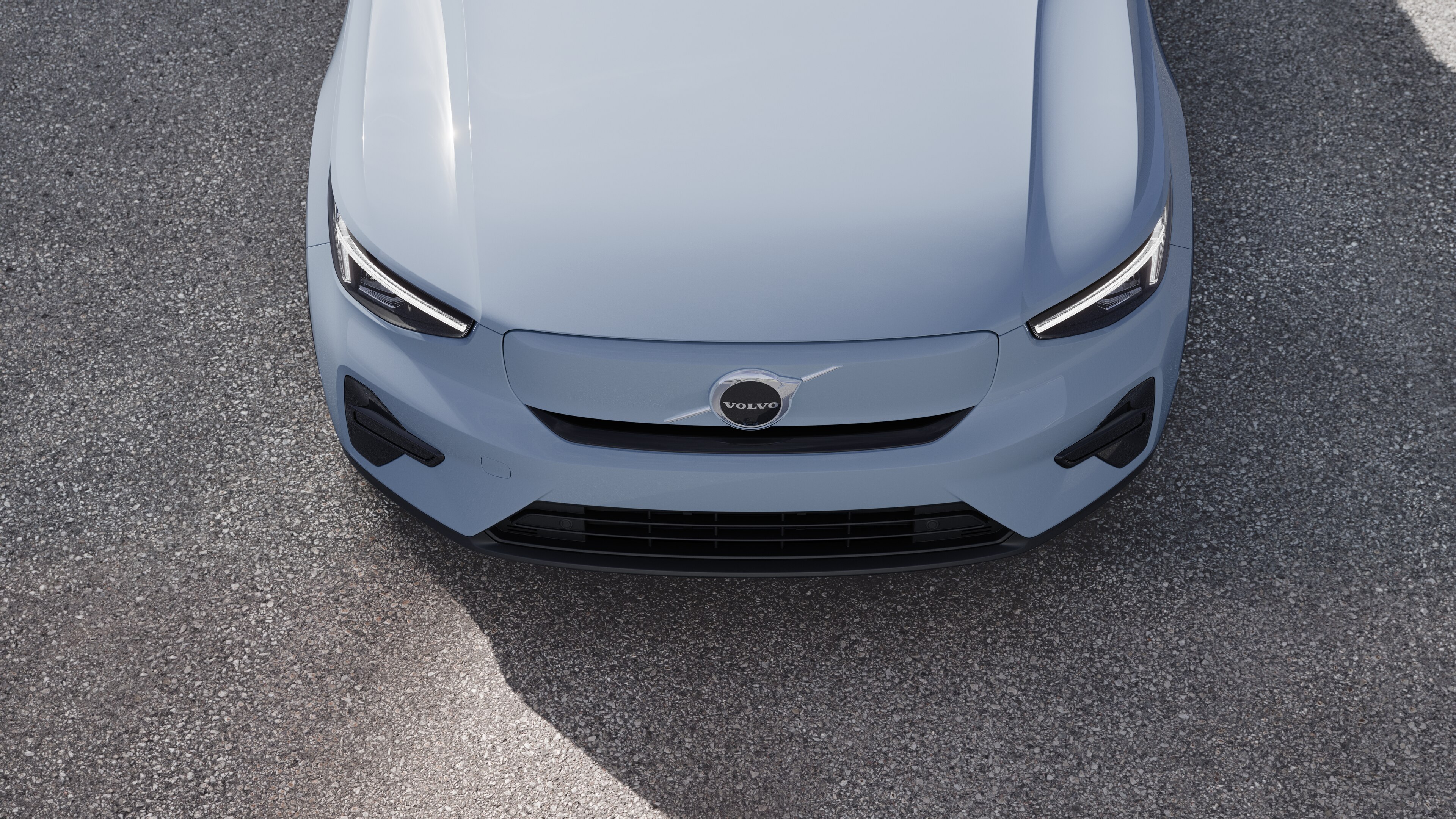 Volvo car exterior in three-quarter view on an urban street background, showing one side, roof, and part of the front.