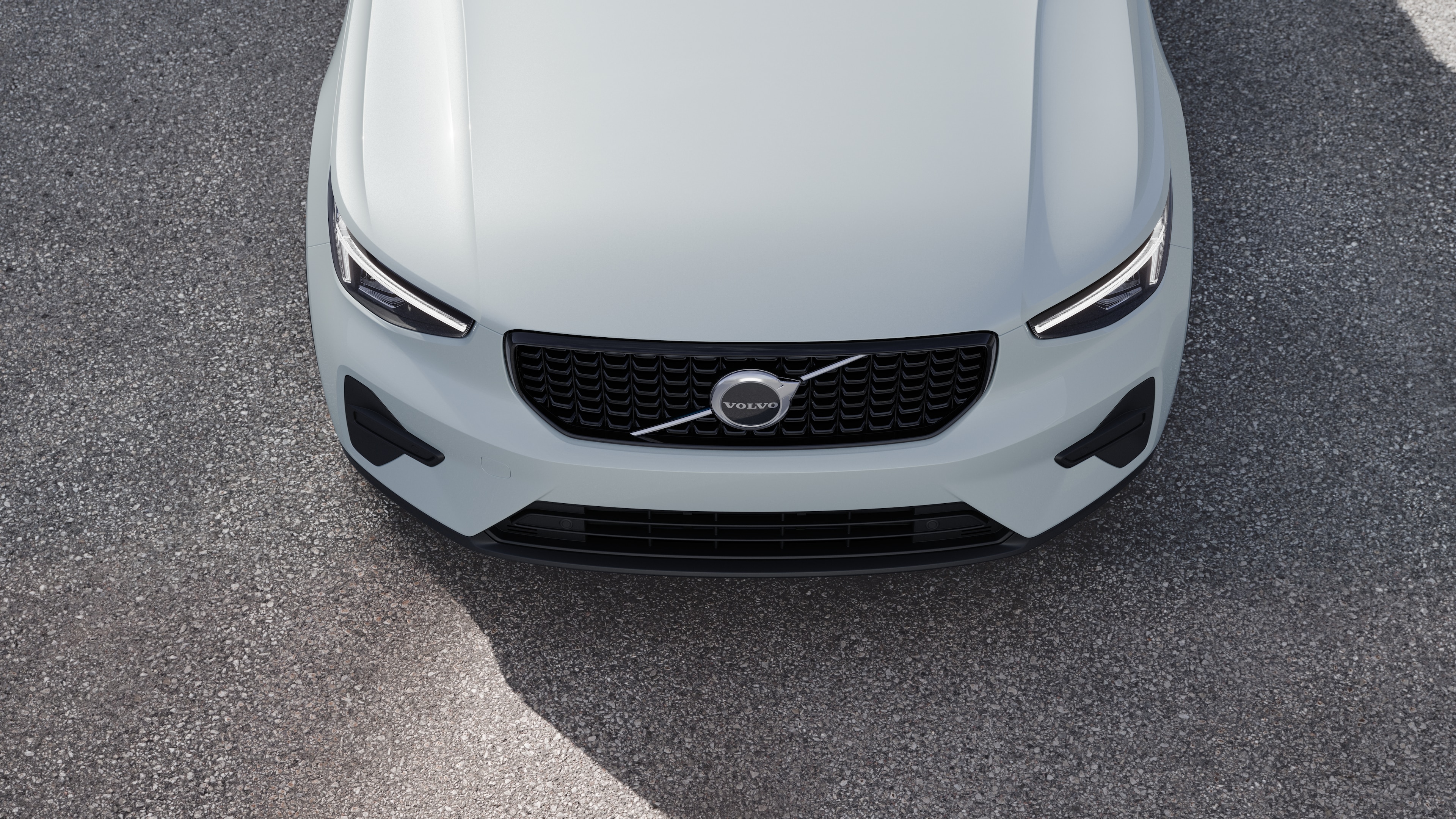 Volvo car exterior in three-quarter view on an urban street background, showing one side, roof, and part of the front.