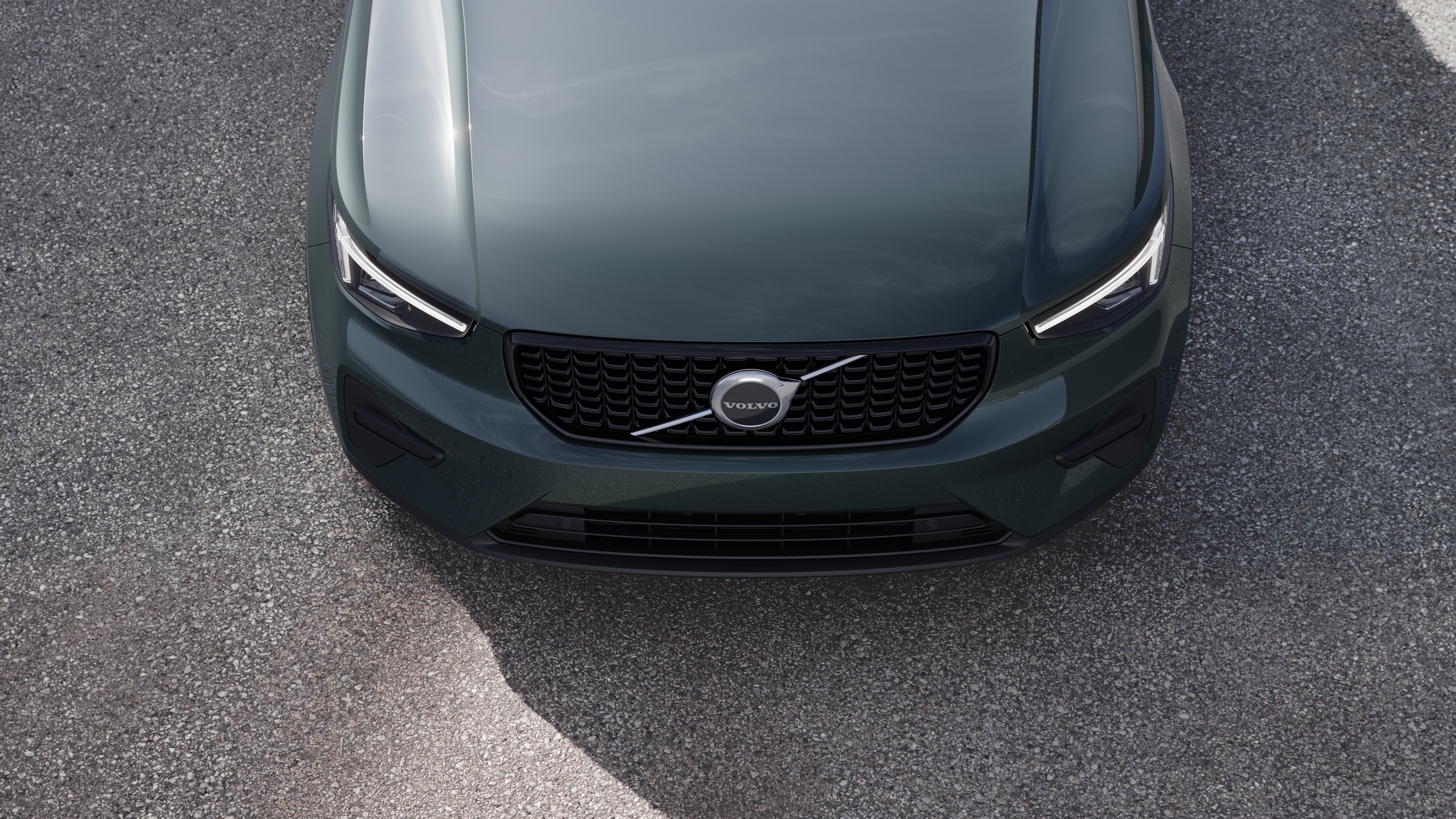 Volvo car exterior in three-quarter view on an urban street background, showing one side, roof, and part of the front.