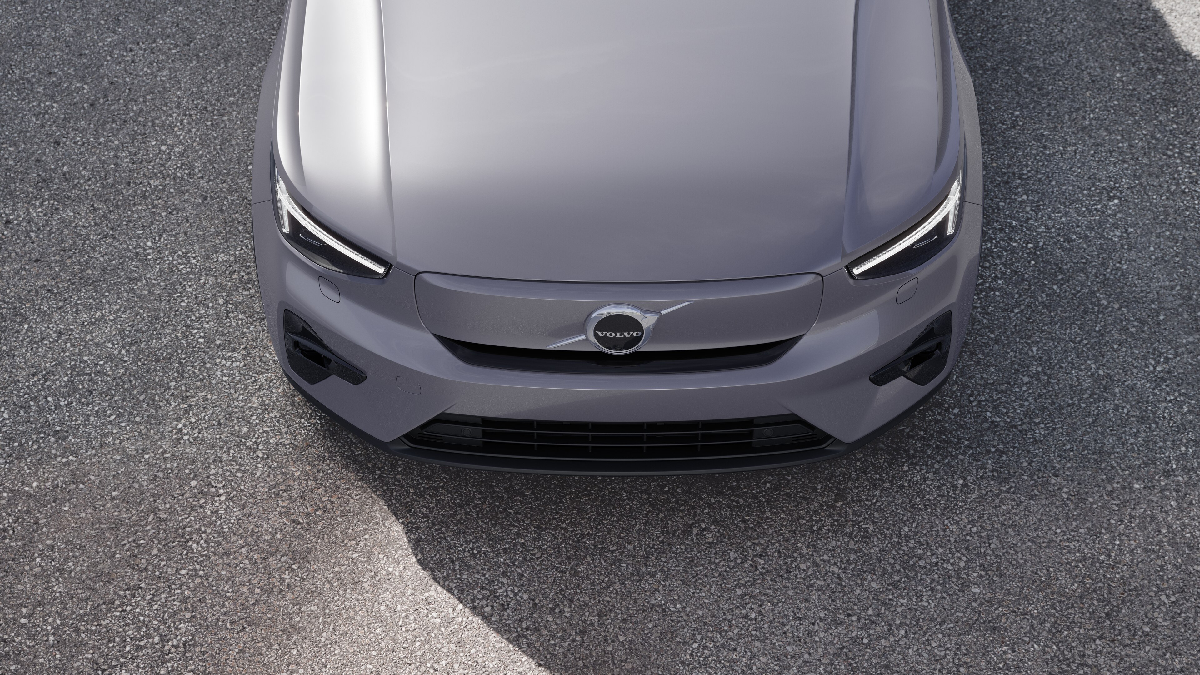 Volvo car exterior in three-quarter view on an urban street background, showing one side, roof, and part of the front.