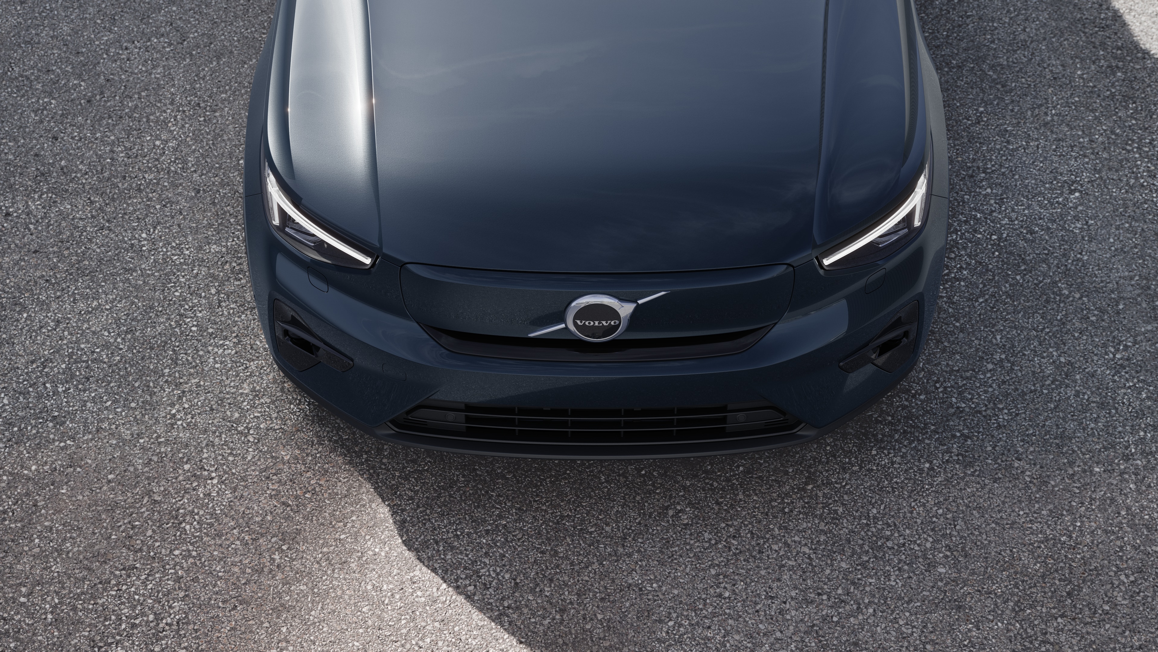 Volvo-bilens eksteriør i trekvartvisning på en bygadebaggrund, der viser den ene side, taget og en del af fronten.