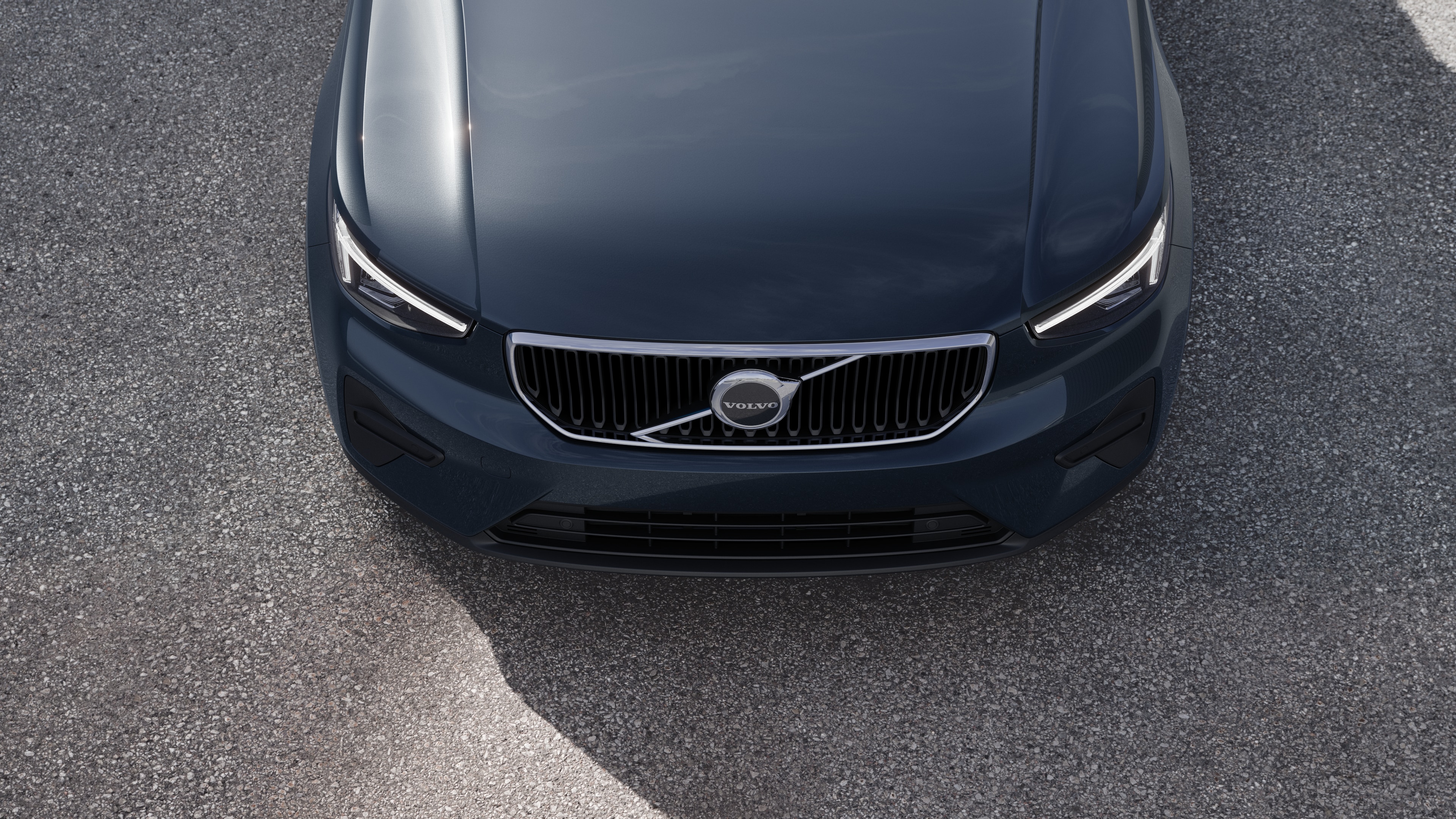 Volvo car exterior in three-quarter view on an urban street background, showing one side, roof, and part of the front.