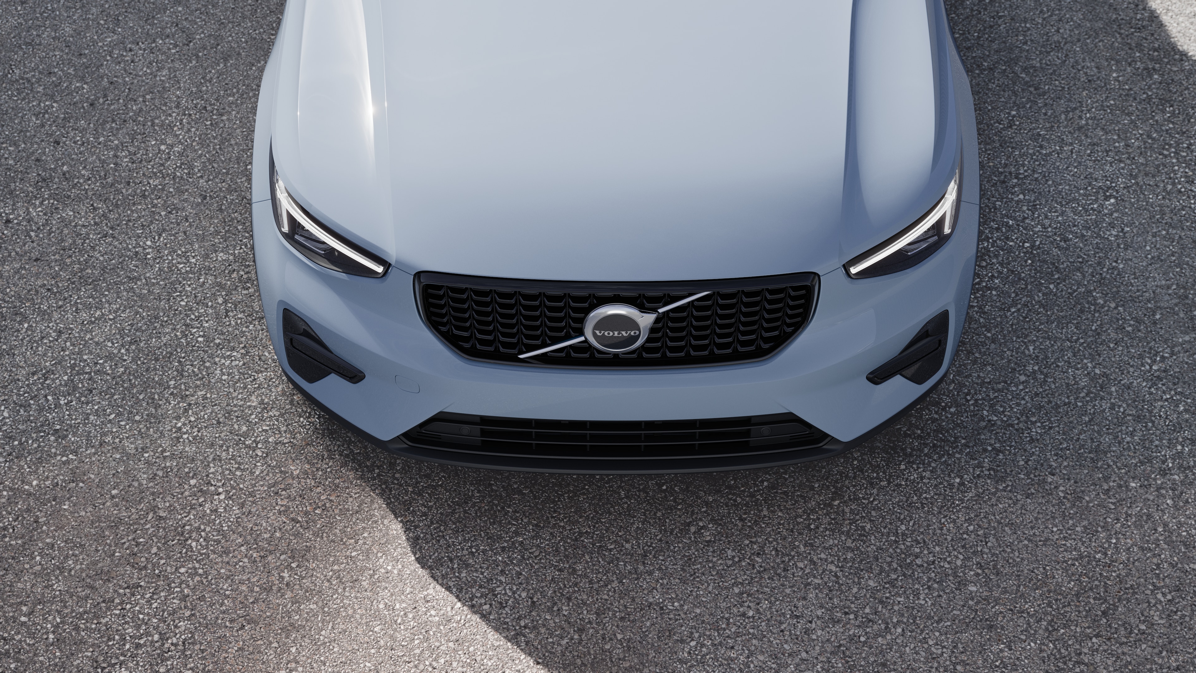 Volvo automašīnas ārpuse trīs ceturtdaļu skatā uz pilsētas ielas fona, parādot vienu pusi, jumtu un daļu priekšpuses.