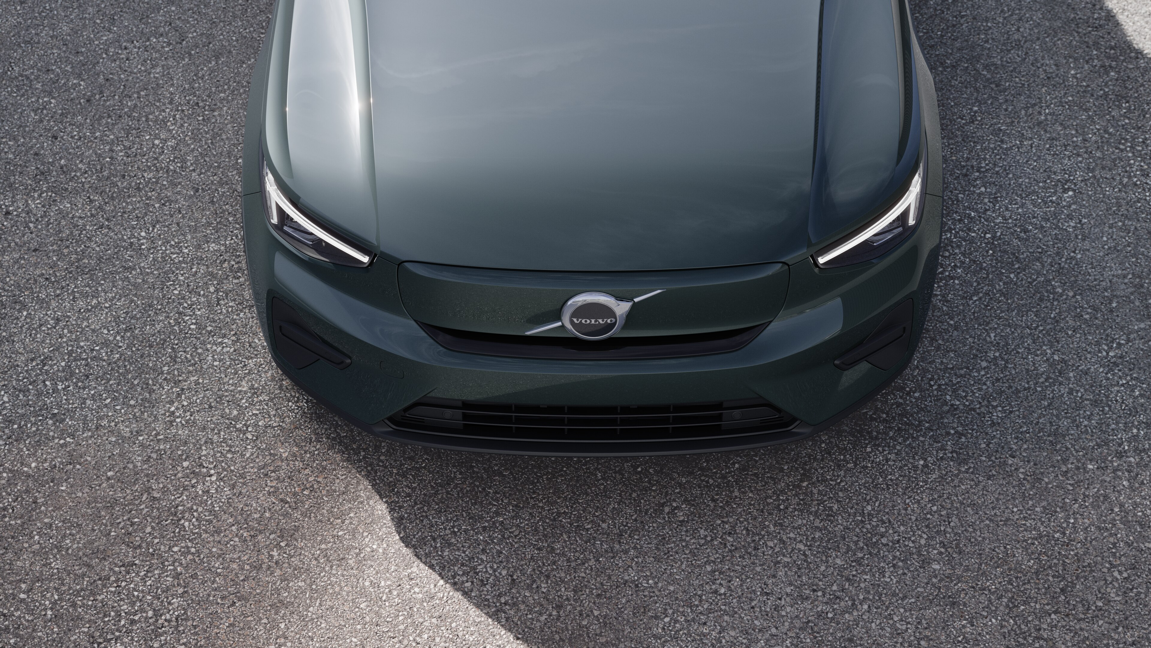 Volvo car exterior in three-quarter view on an urban street background, showing one side, roof, and part of the front.