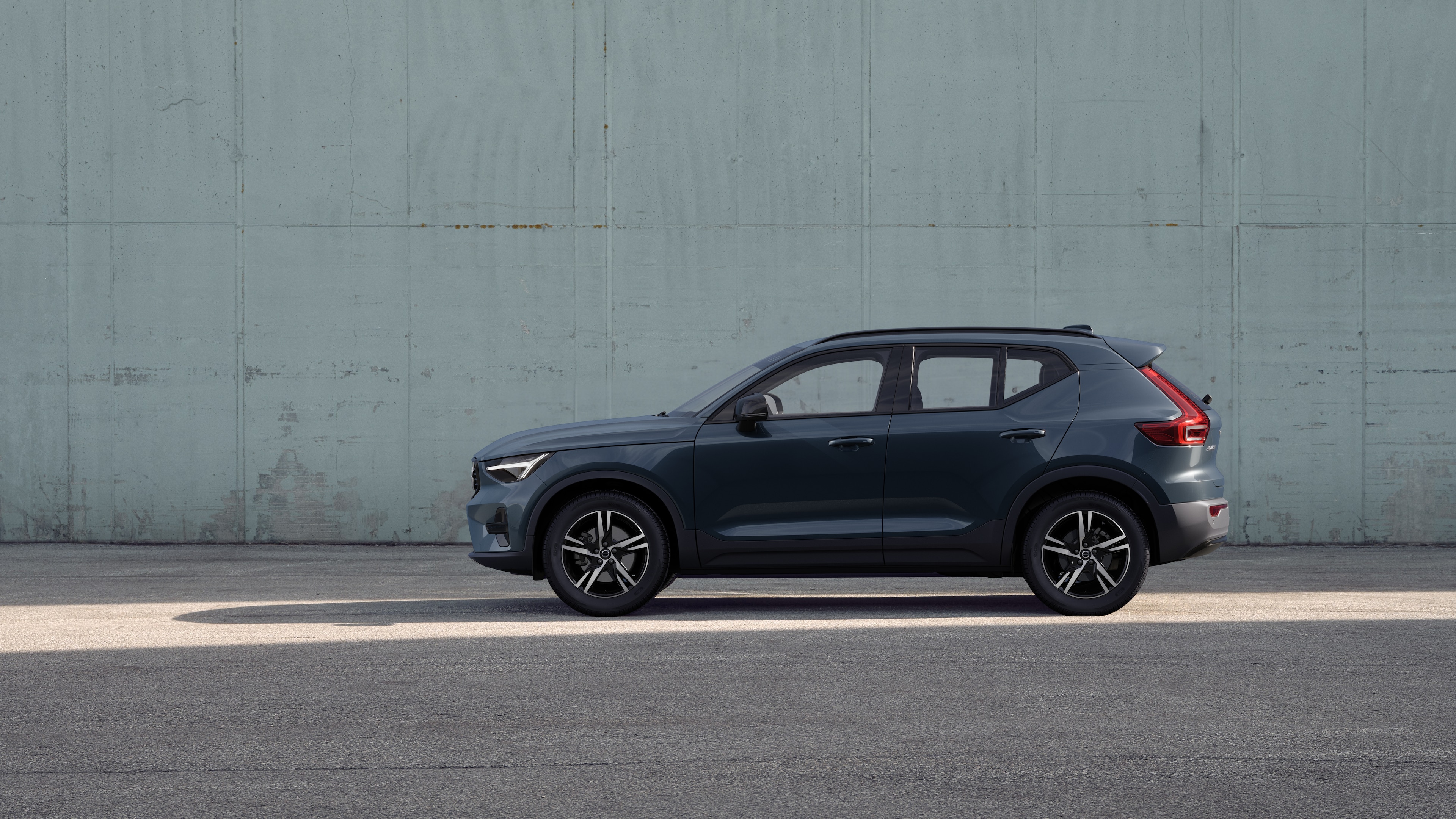 Voiture Volvo, vue latérale, garée contre un mur en béton.