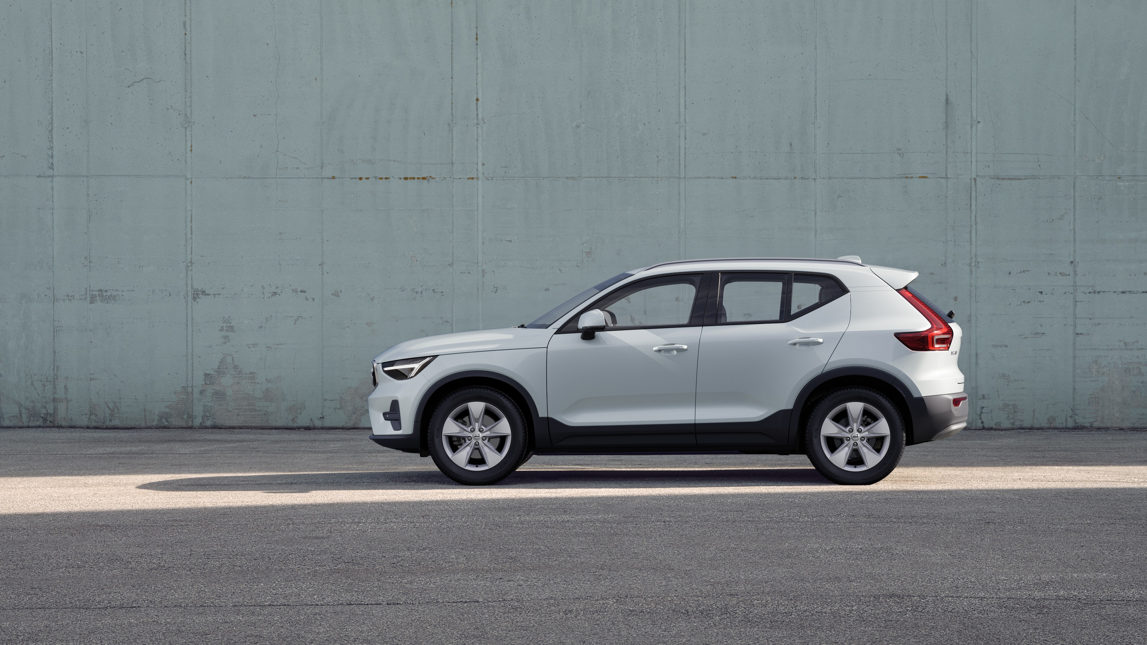 볼보 자동차, 측면도, 일반 콘크리트 벽 배경에 주차되어 있습니다.