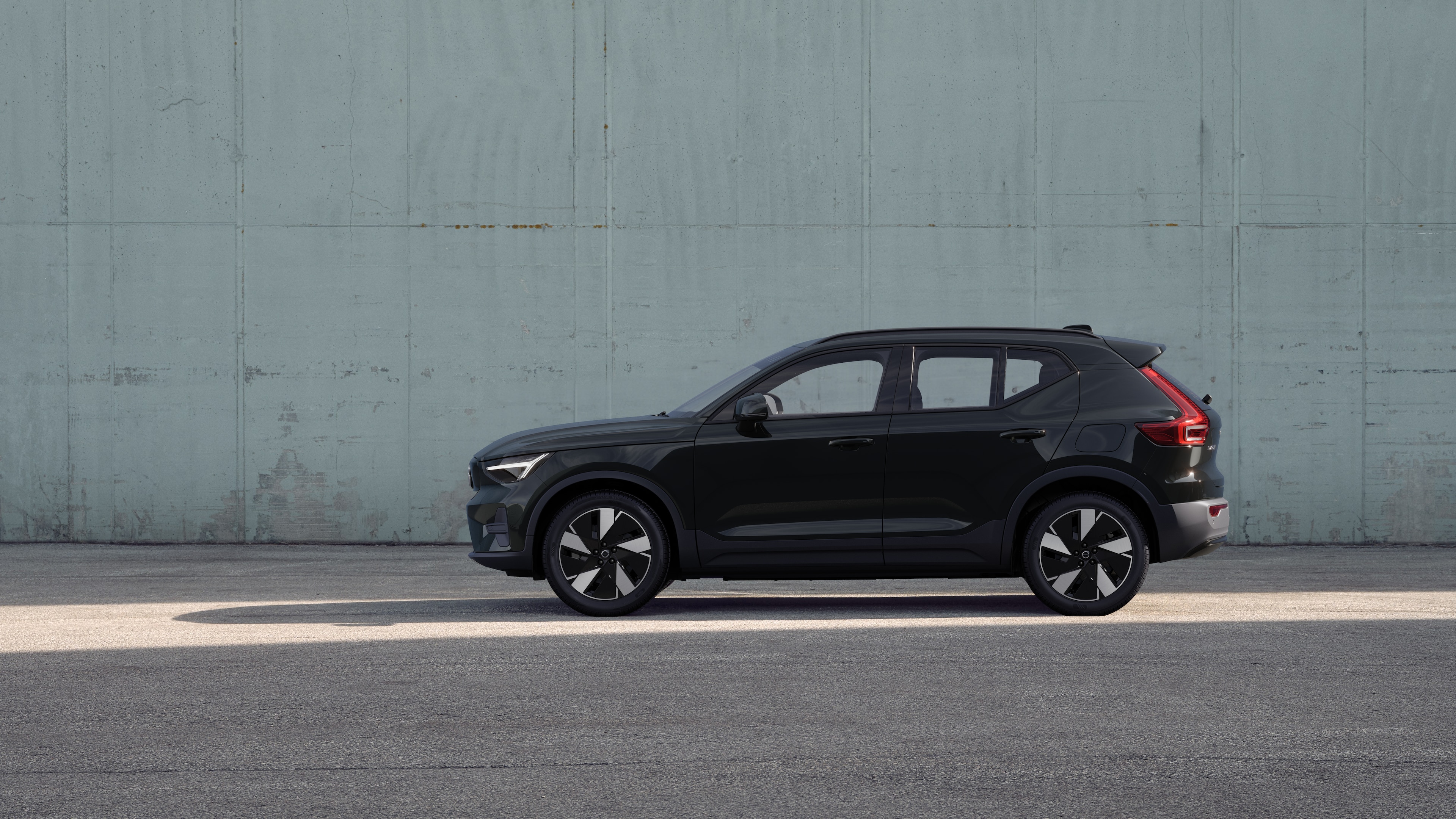 Vehículo Volvo, vista lateral, estacionado contra un fondo de pared de hormigón.