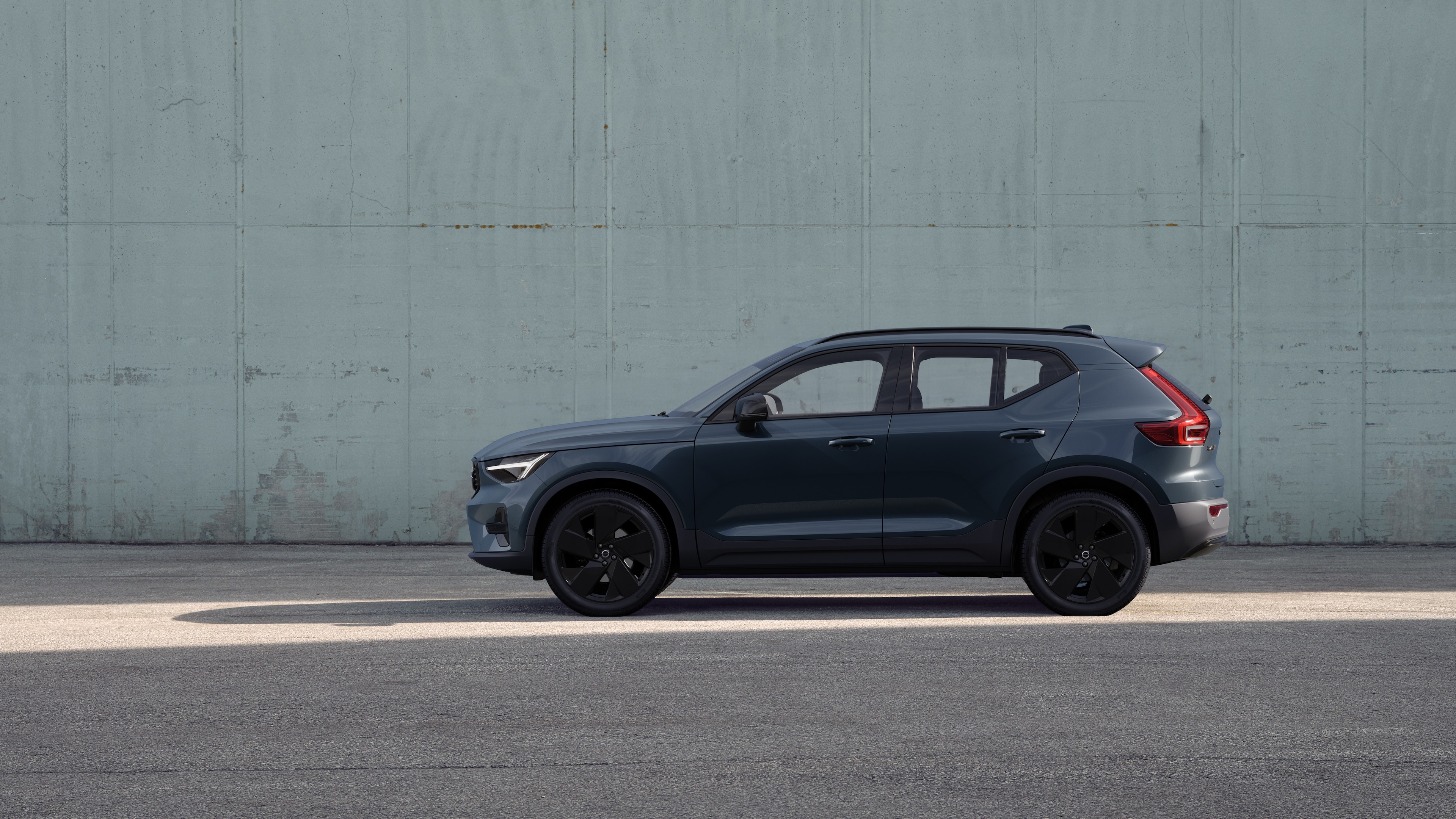 Volvo Fahrzeug, Seitenansicht, geparkt vor einer schlichten Betonwand.