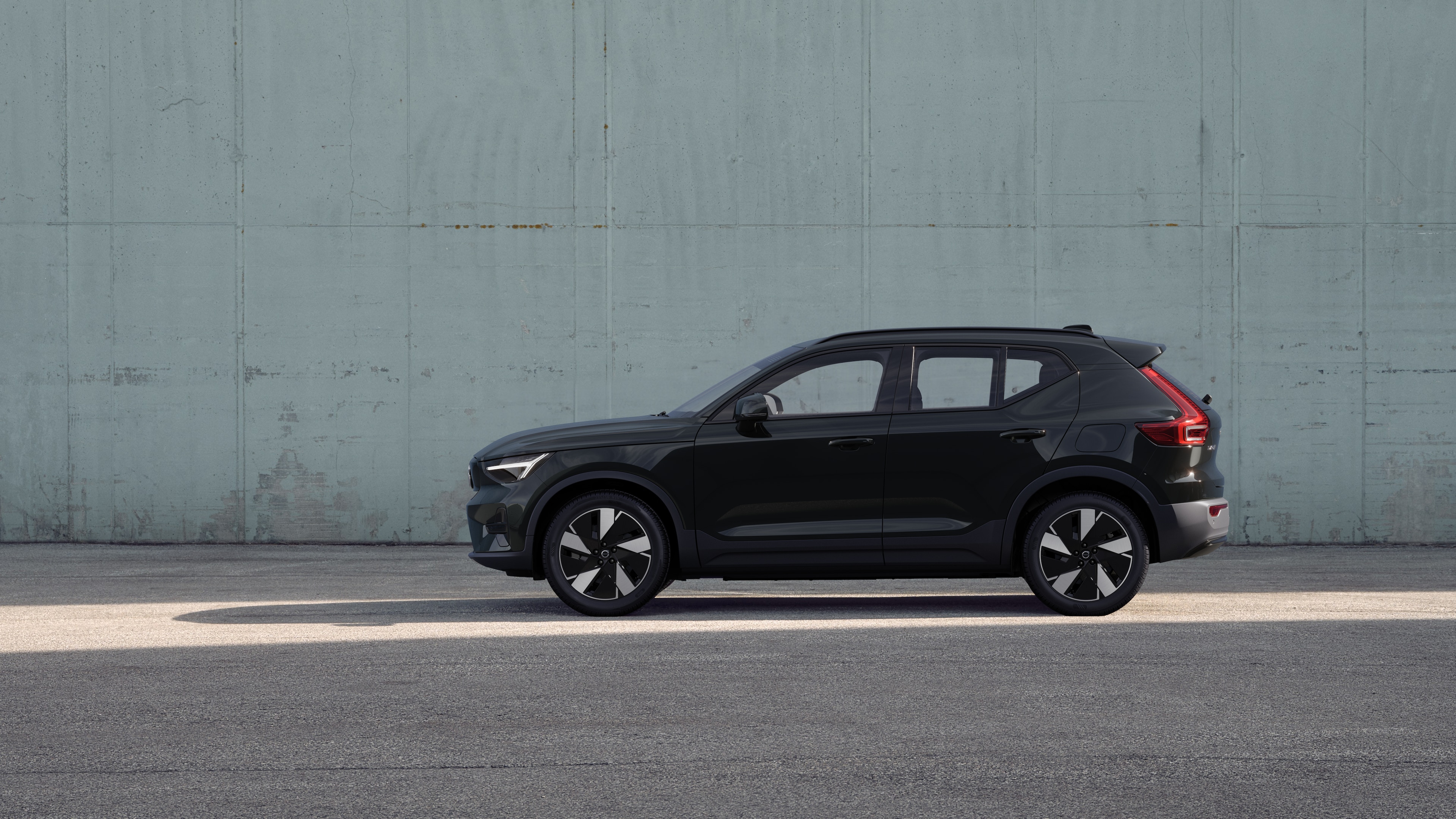 Vehículo Volvo, vista lateral, estacionado contra un fondo de pared de hormigón.
