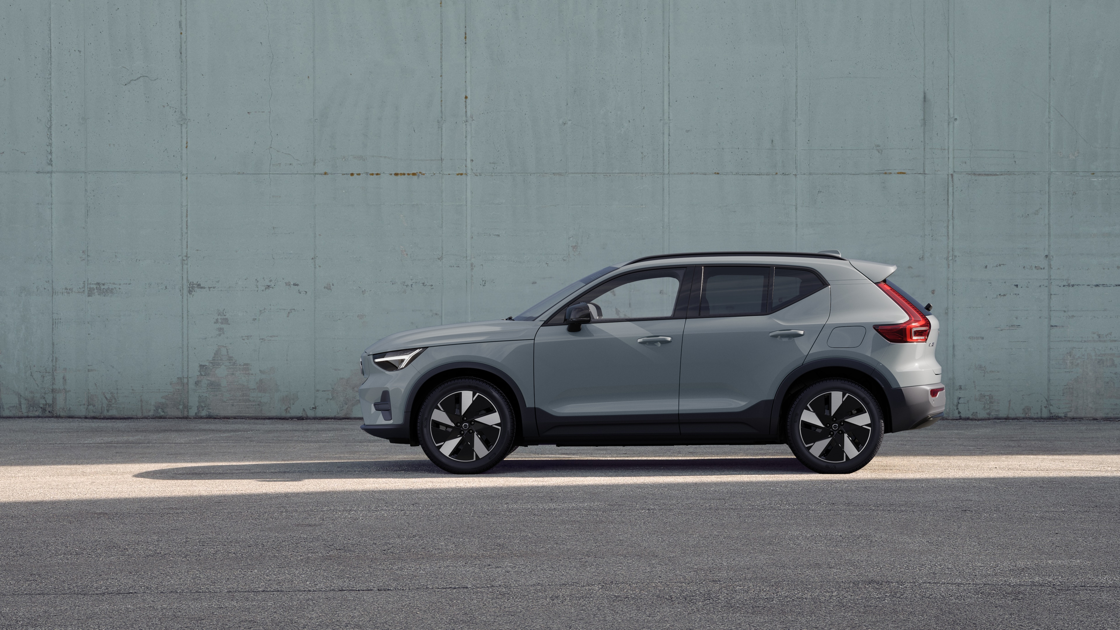 Voiture Volvo, vue latérale, garée sur un fond de mur en béton.