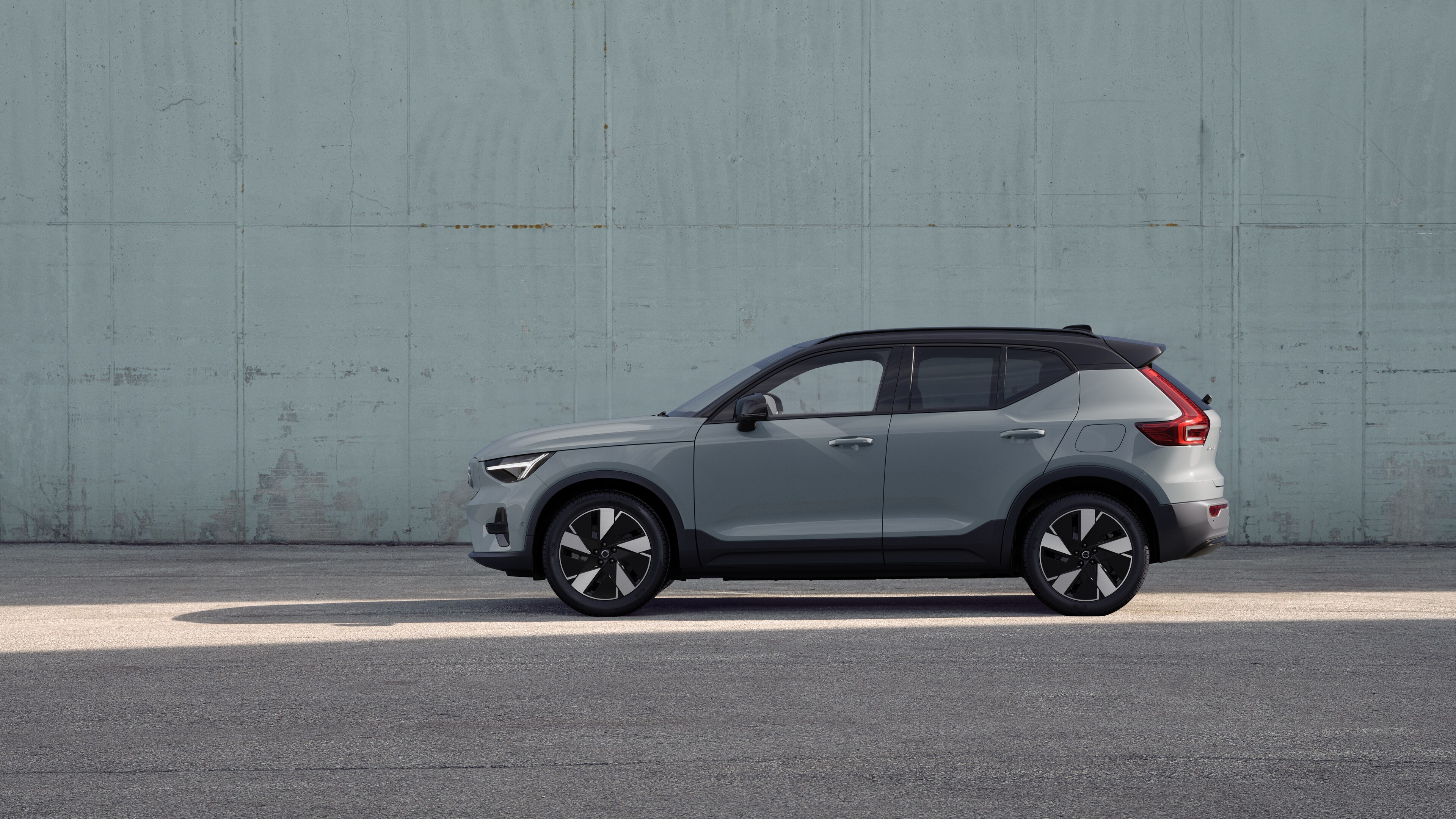 Voiture Volvo, vue latérale, garée sur un fond de mur en béton.