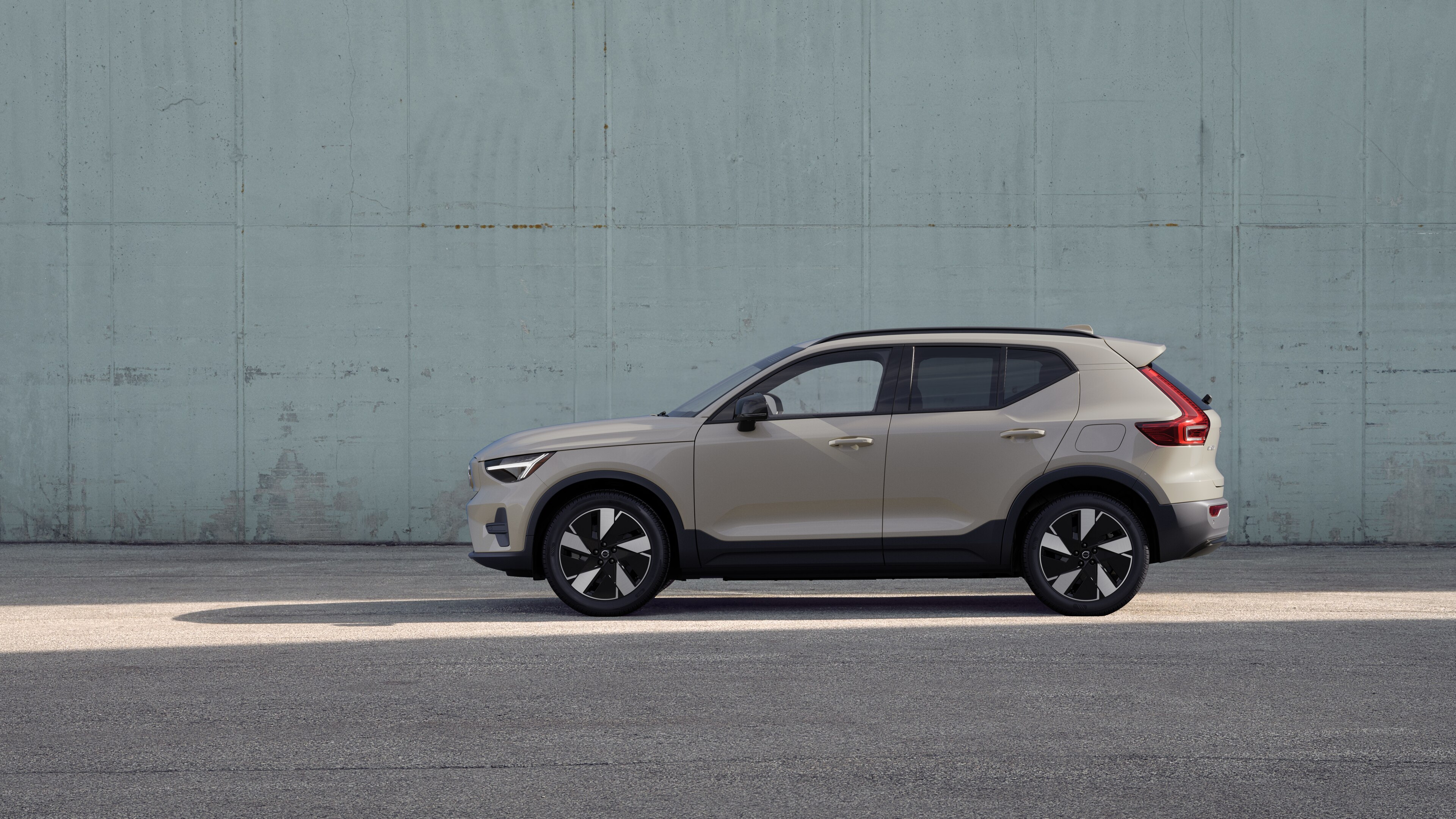 Vehículo Volvo, vista lateral, estacionado contra un fondo de pared de hormigón.