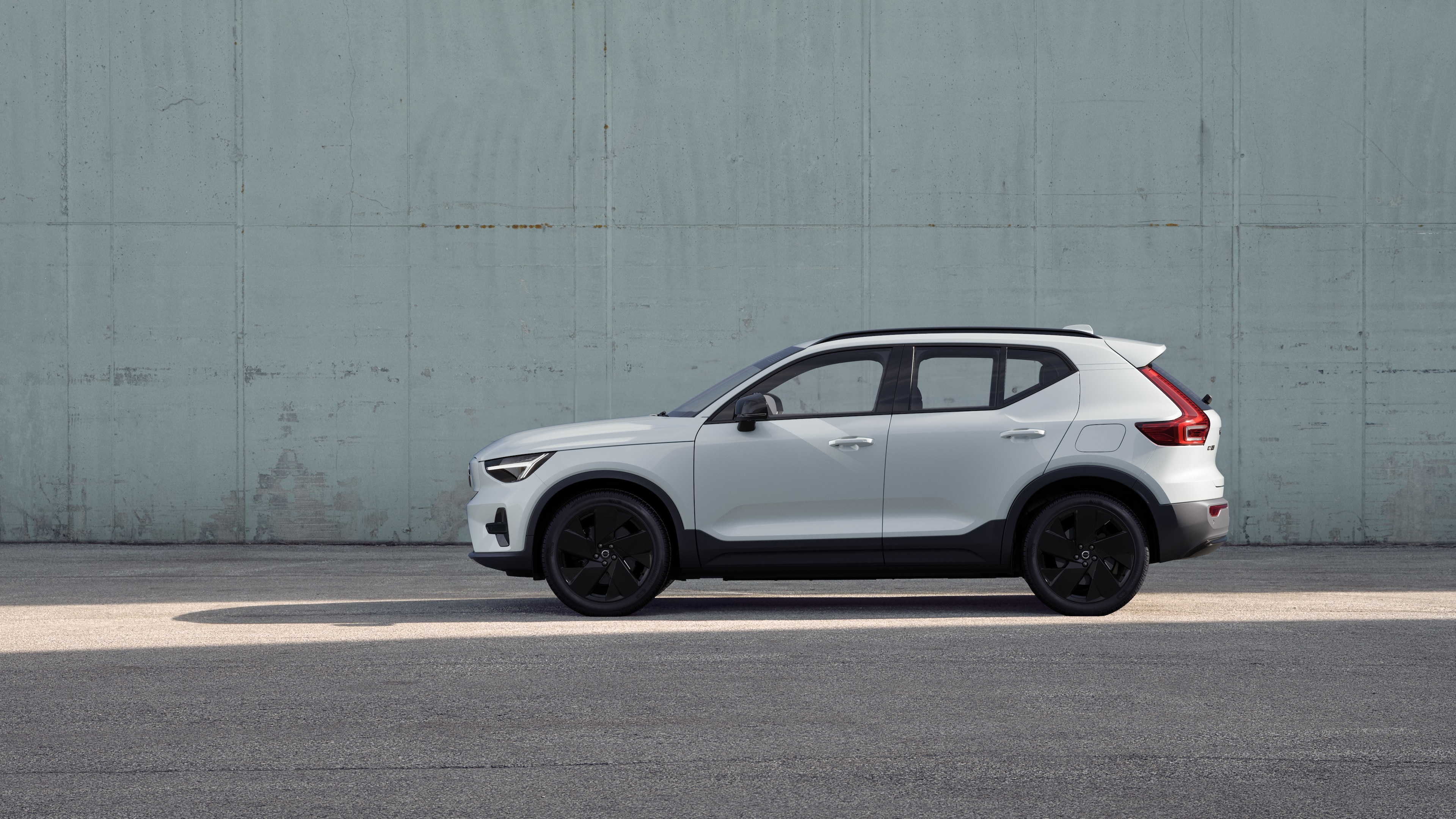 Volvo Fahrzeug, Seitenansicht, geparkt vor einer schlichten Betonwand.