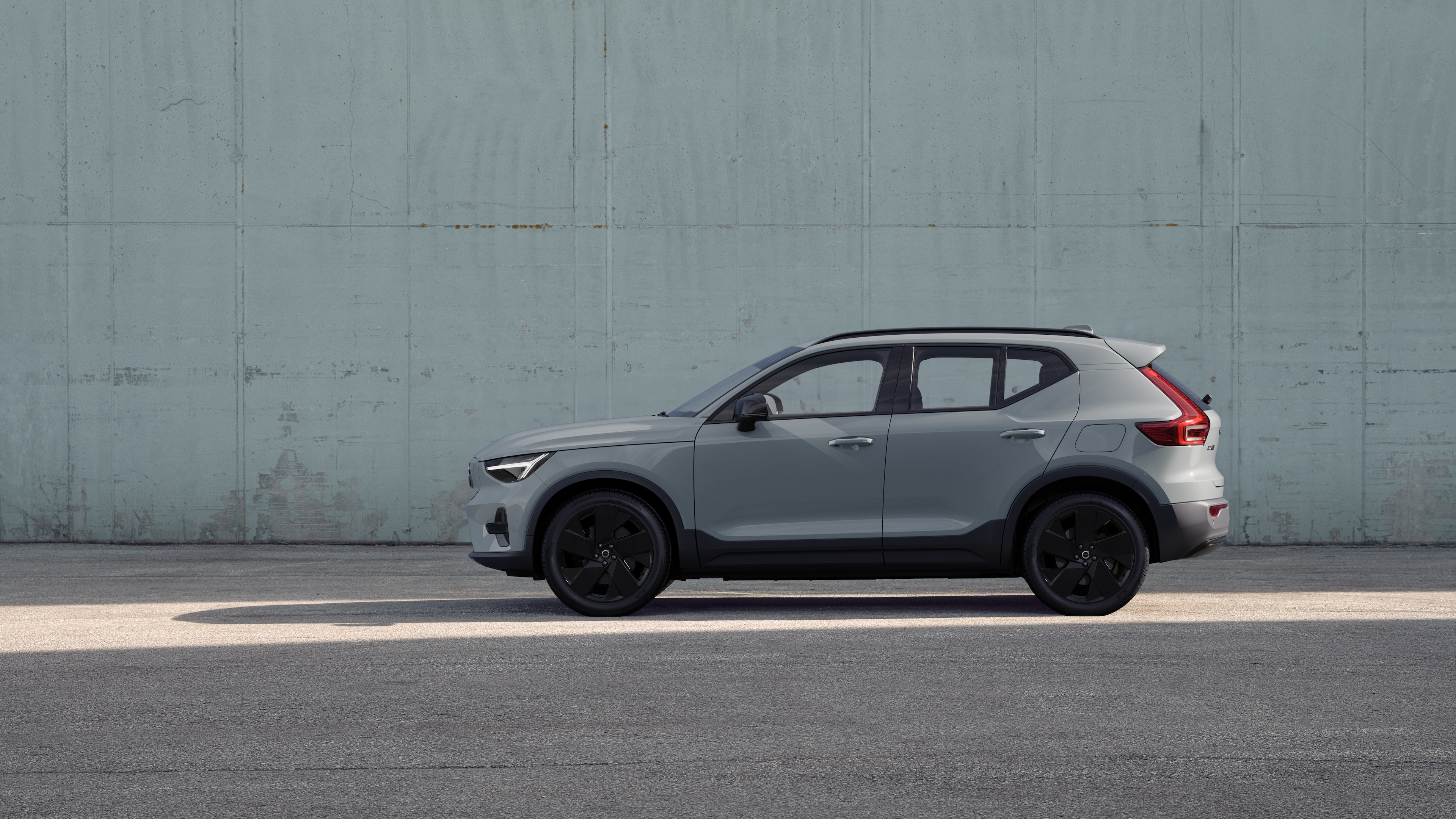 Volvo Fahrzeug, Seitenansicht, geparkt vor einer schlichten Betonwand.