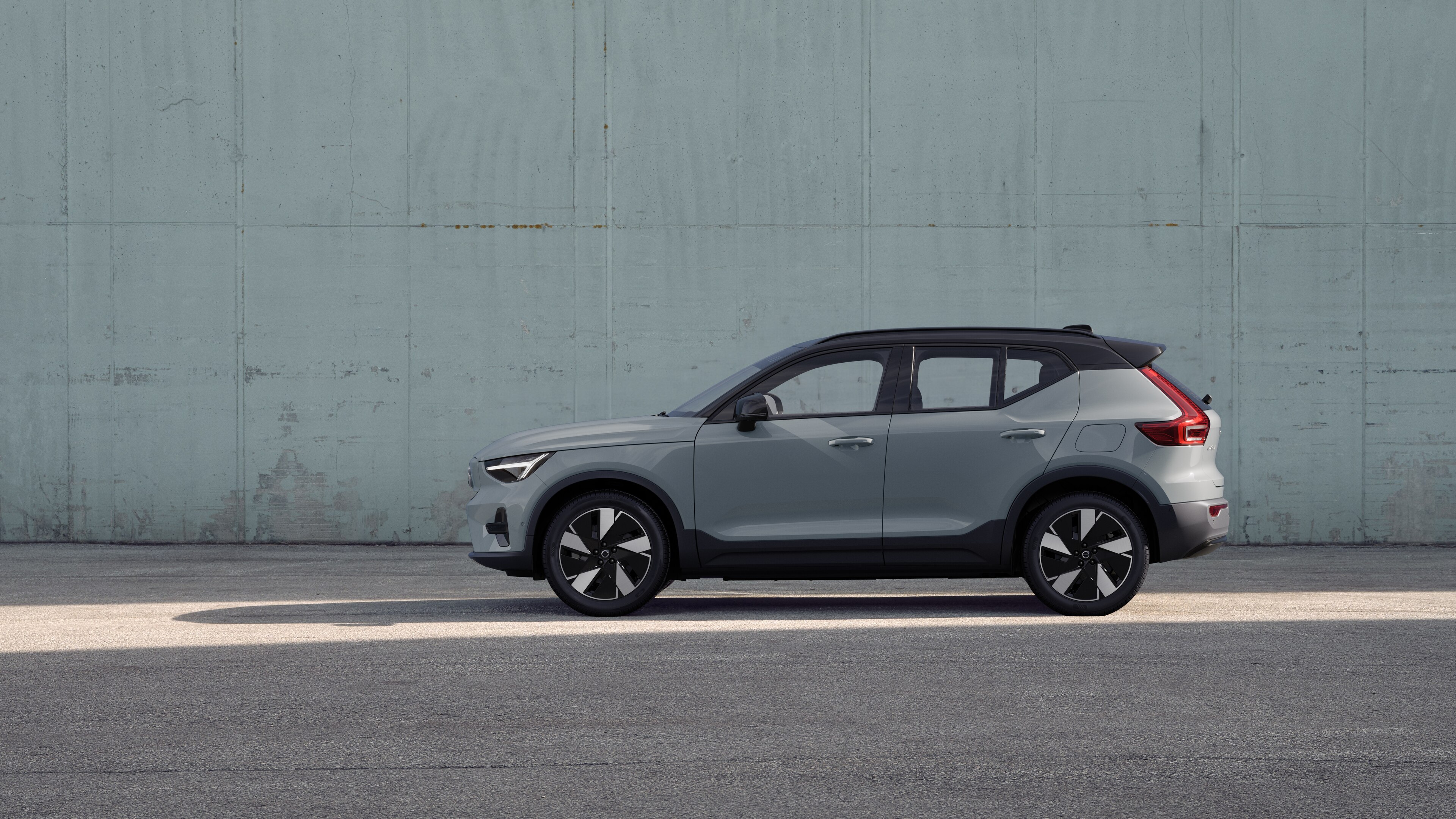 Voiture Volvo, vue latérale, garée sur un fond de mur en béton.