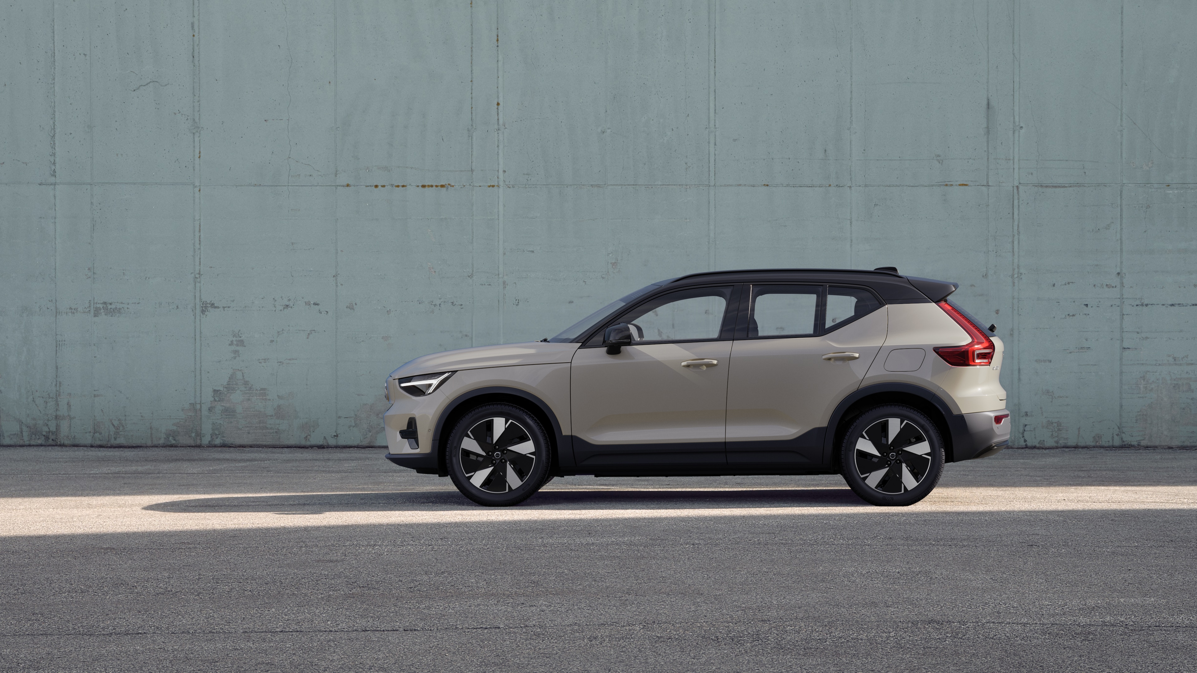 Un'auto Volvo, vista laterale, parcheggiata sullo sfondo di un muro di cemento.