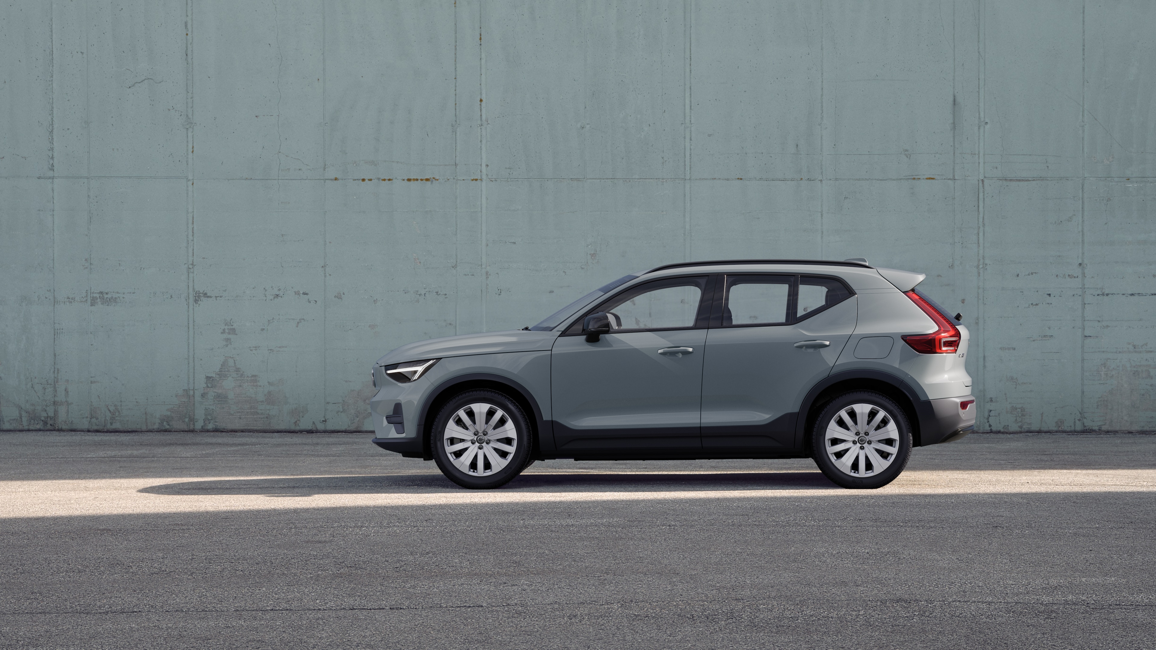 Voiture Volvo, vue latérale, garée sur un fond de mur en béton.