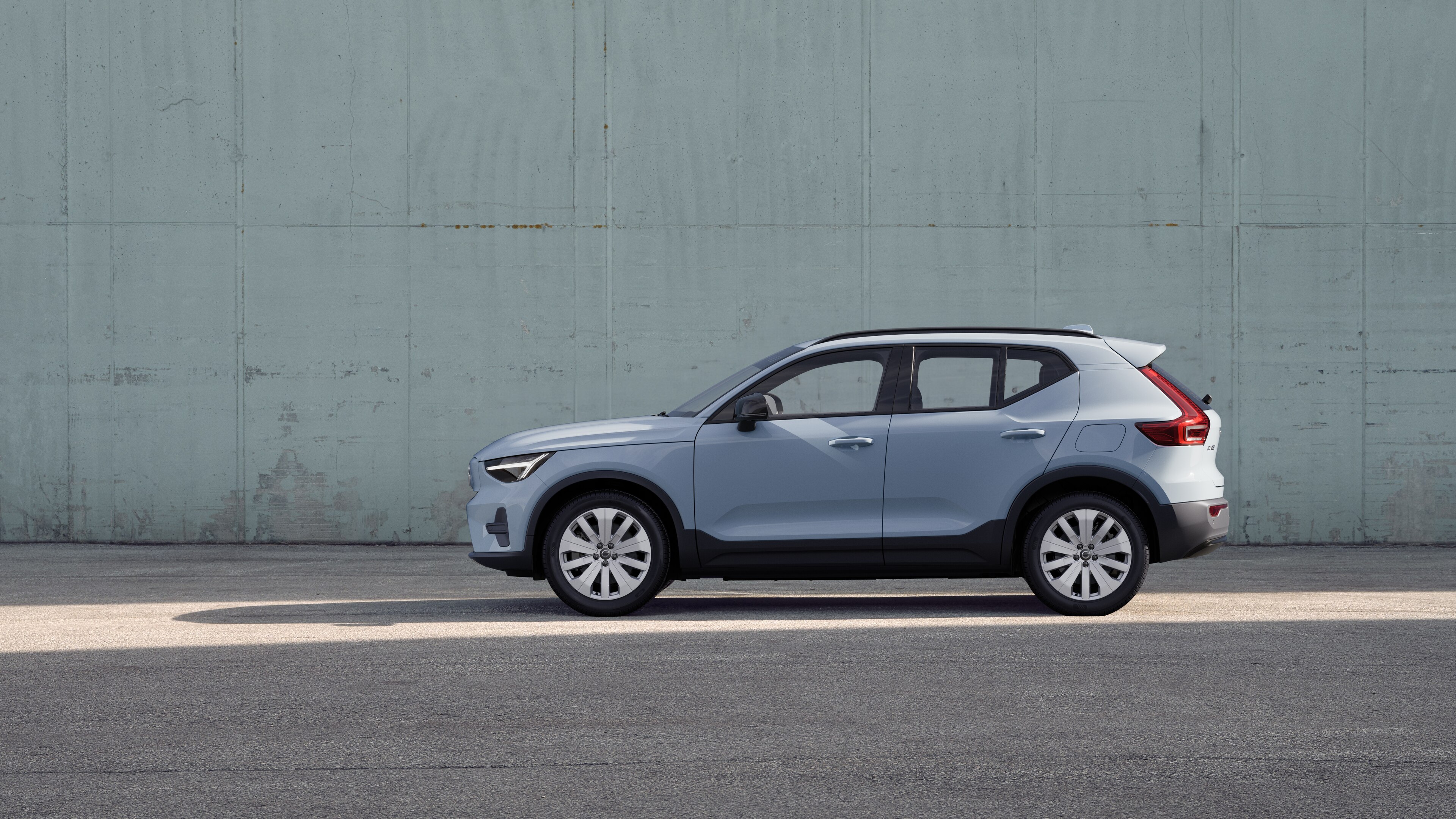 Un'auto Volvo, vista laterale, parcheggiata sullo sfondo di un muro di cemento.