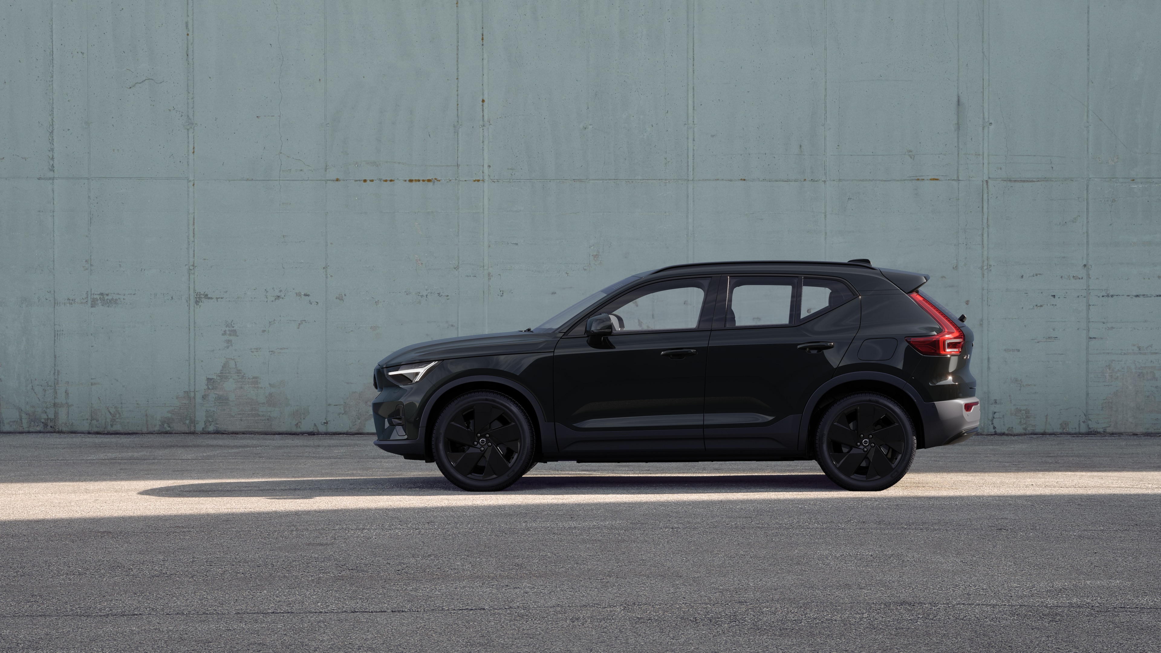 Volvo-bil set fra siden, parkeret mod en almindelig betonvægbaggrund.