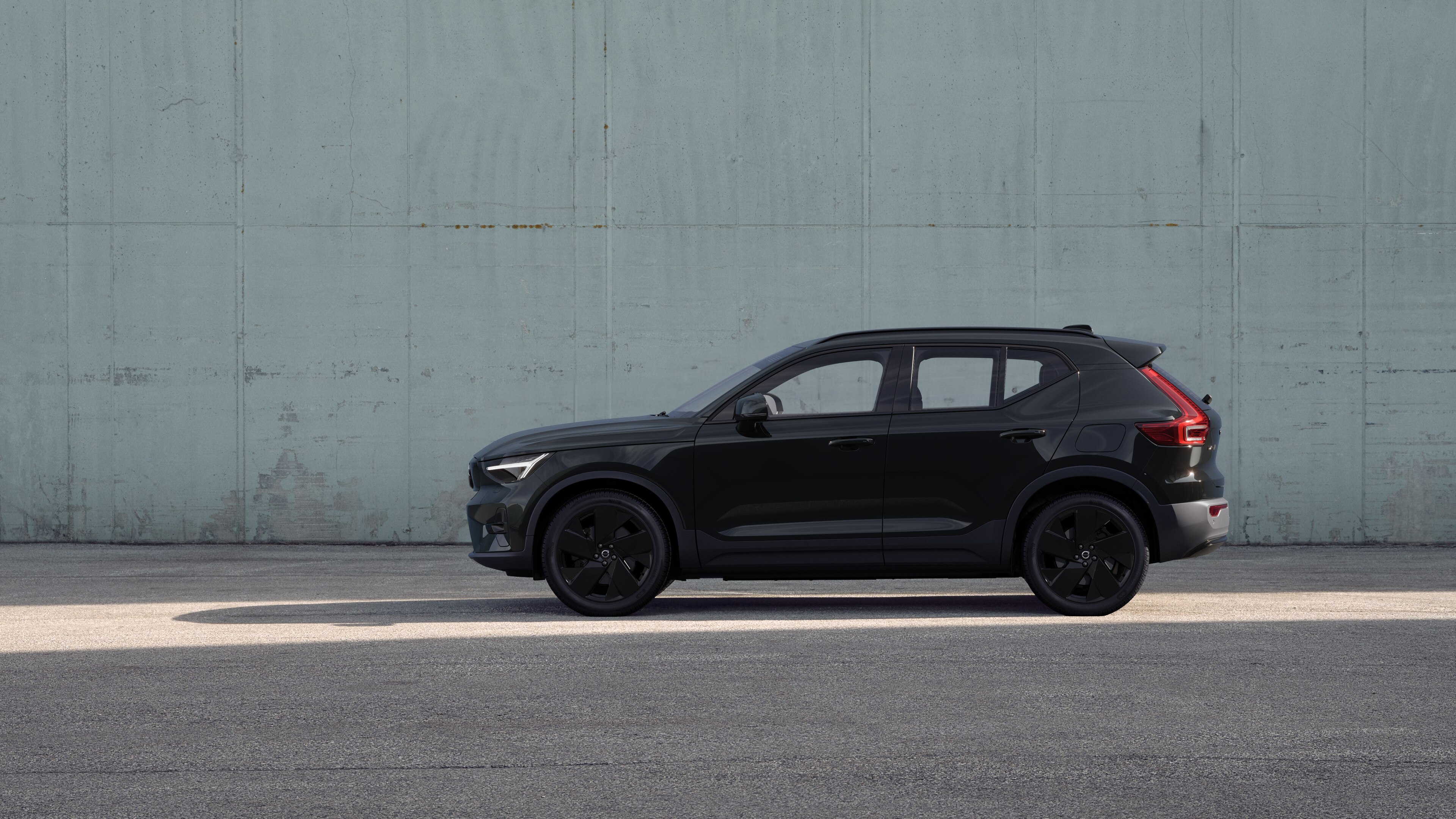 Volvo, sedd från sidan, parkerad mot en enkel betongvägg.