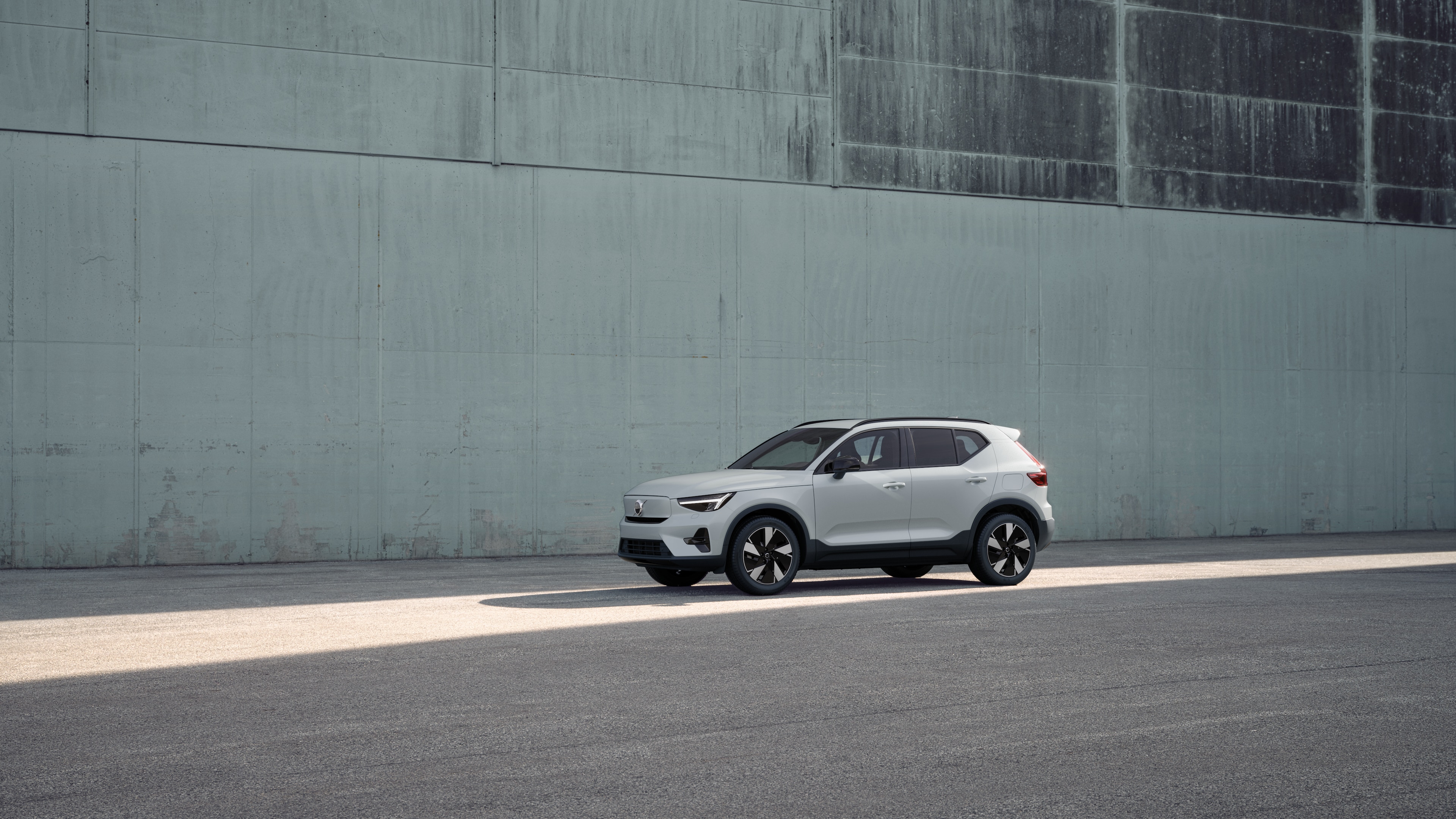 Volvo-bilens ydre i trekvartbillede mod en industriel betonvægbaggrund.