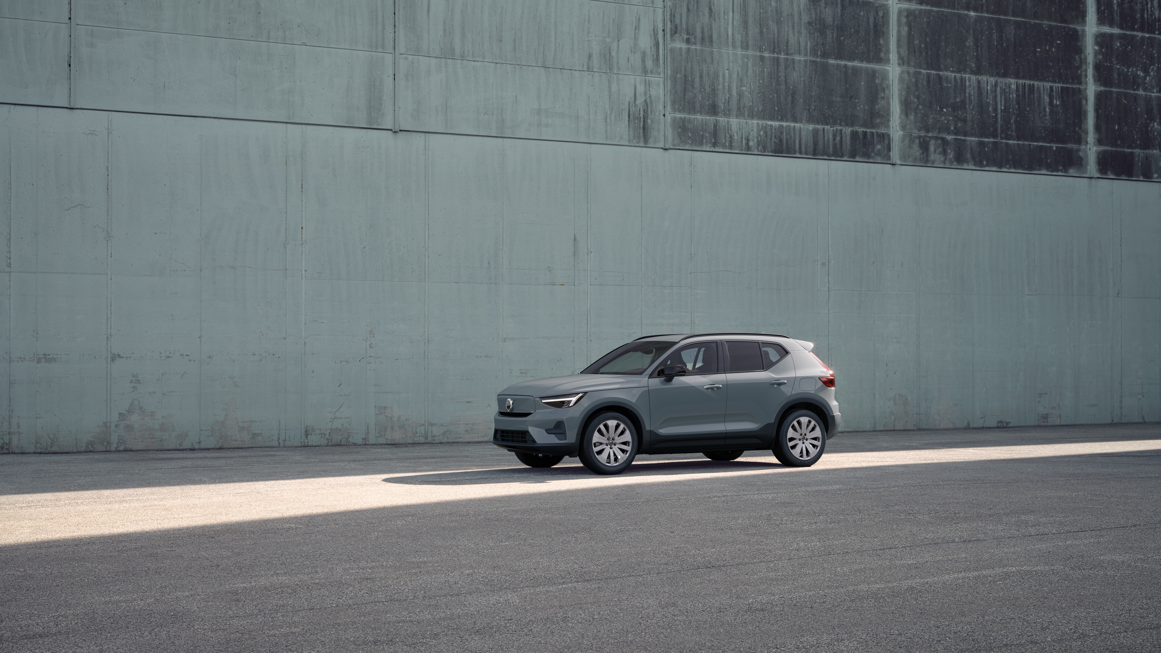 Volvo-bil utvendig i trekvart visning mot en industriell betongveggbakgrunn.