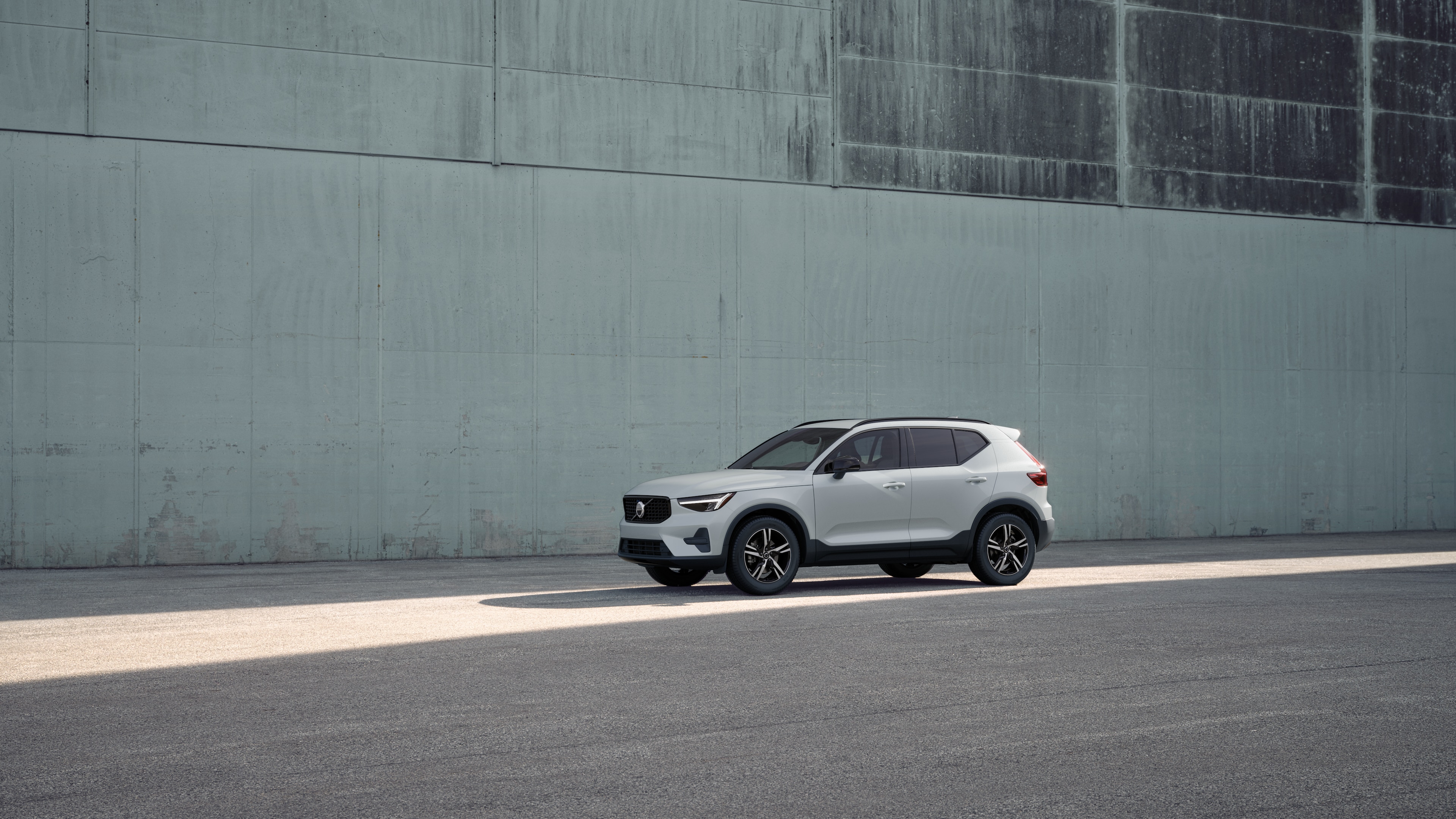 Volvo car exterior in three-quarter view against an industrial concrete wall background.