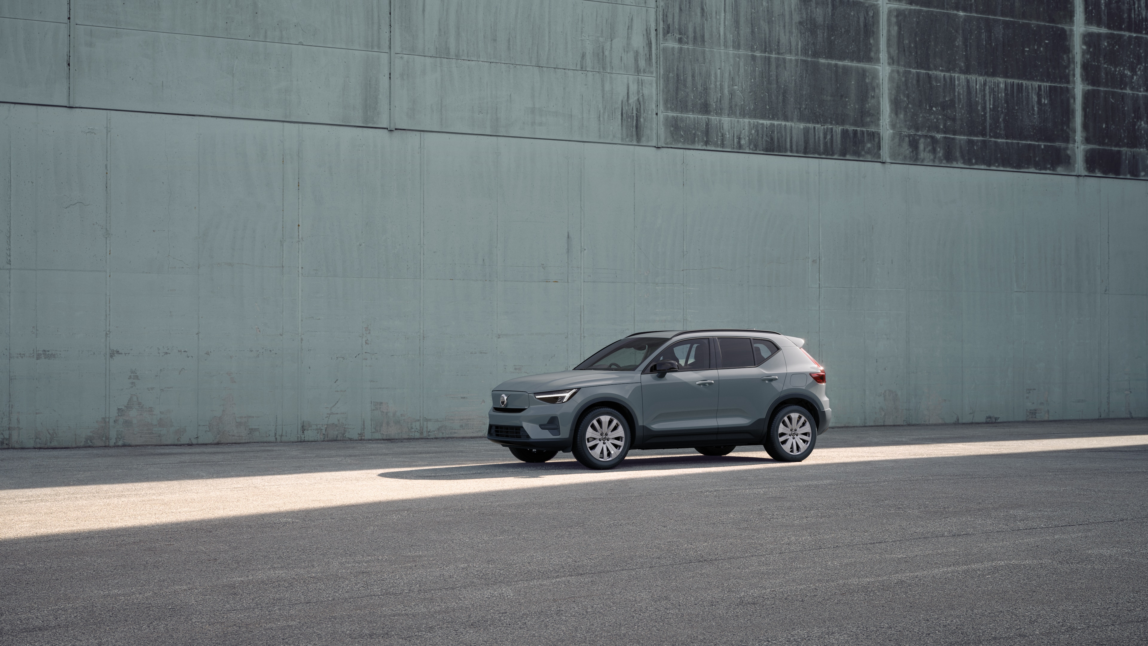 Volvo car exterior in three-quarter view against an industrial concrete wall background.