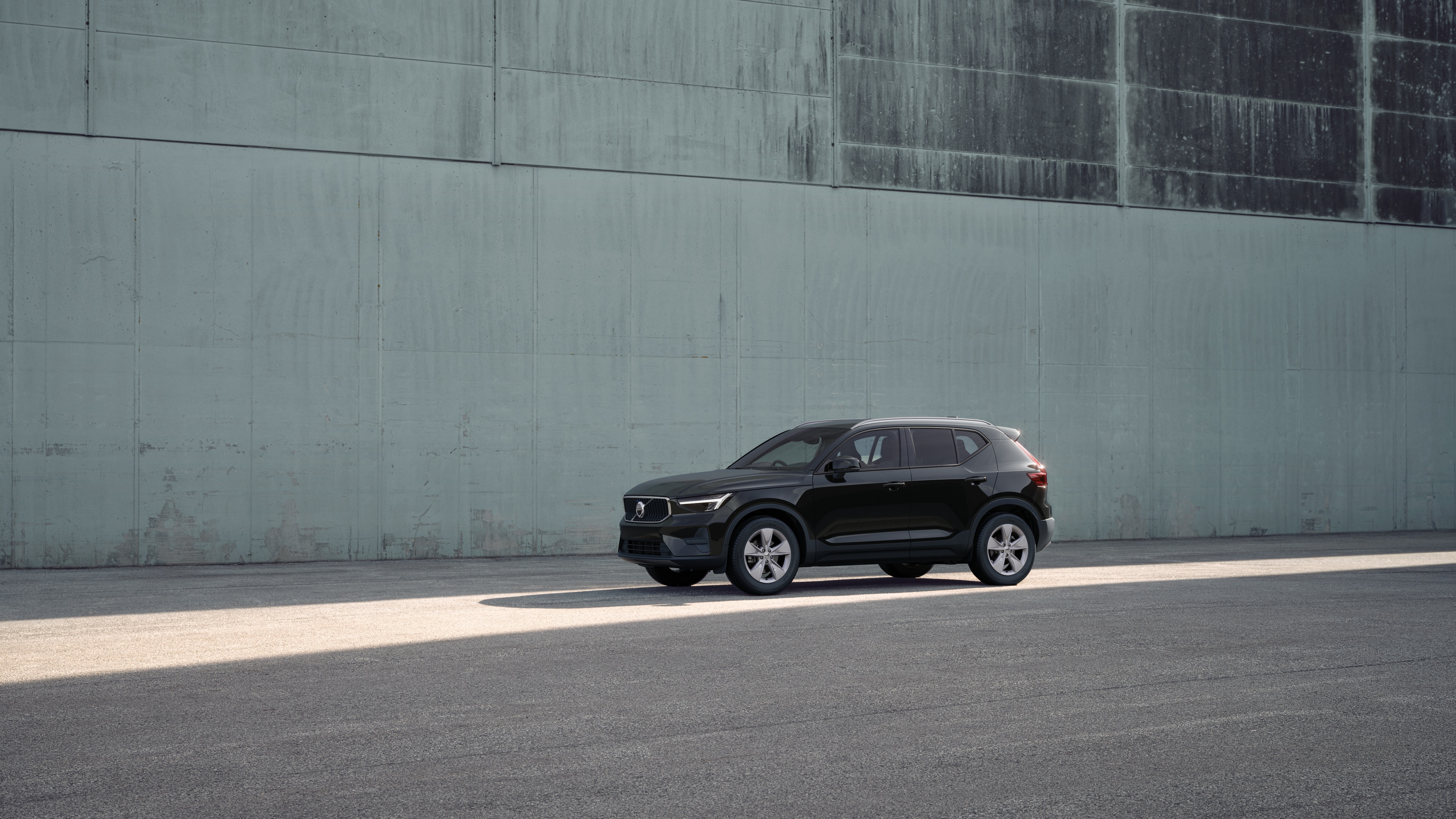 Volvo car exterior in three-quarter view against an industrial concrete wall background.