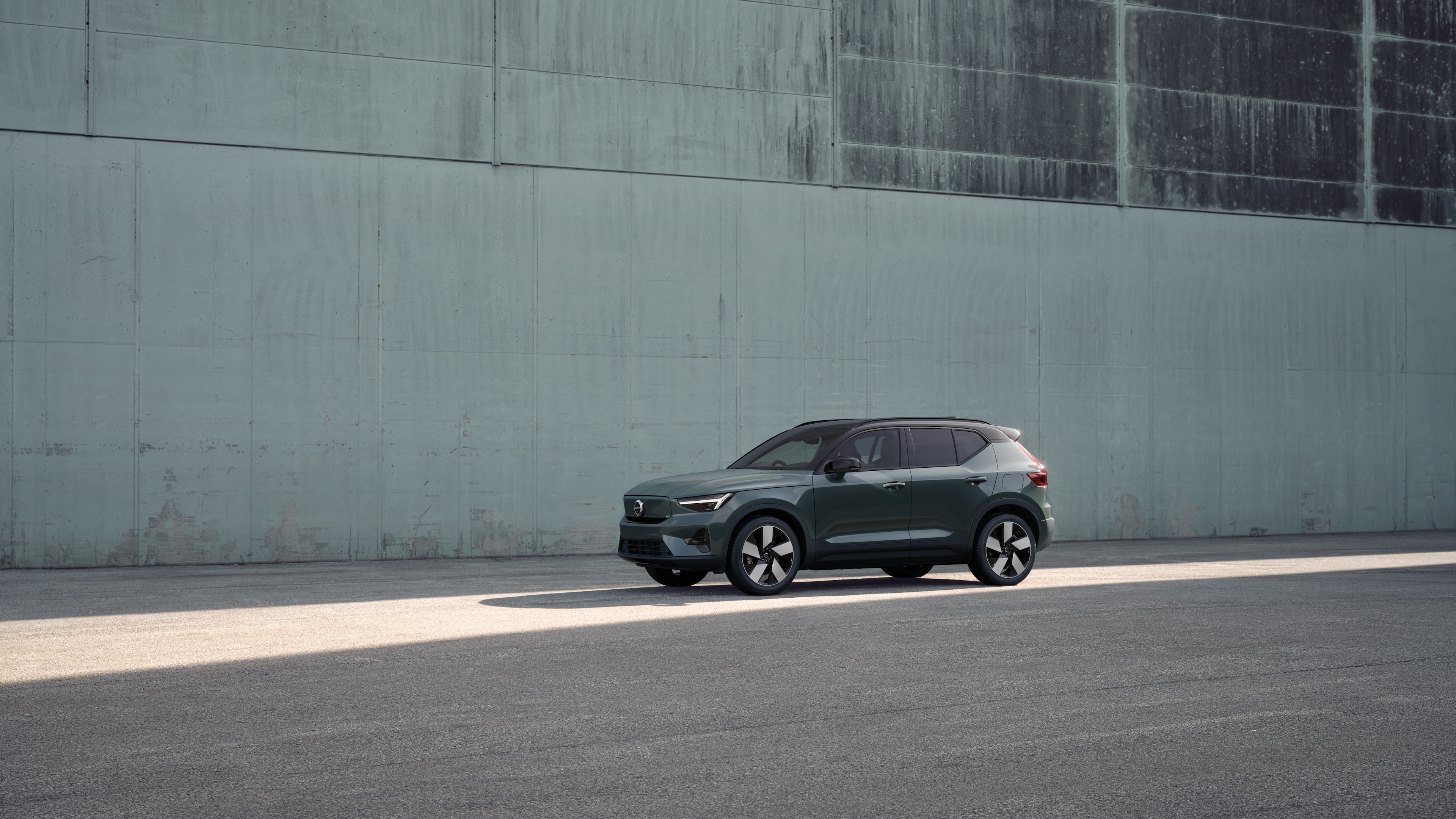 Volvo car exterior in three-quarter view against an industrial concrete wall background.