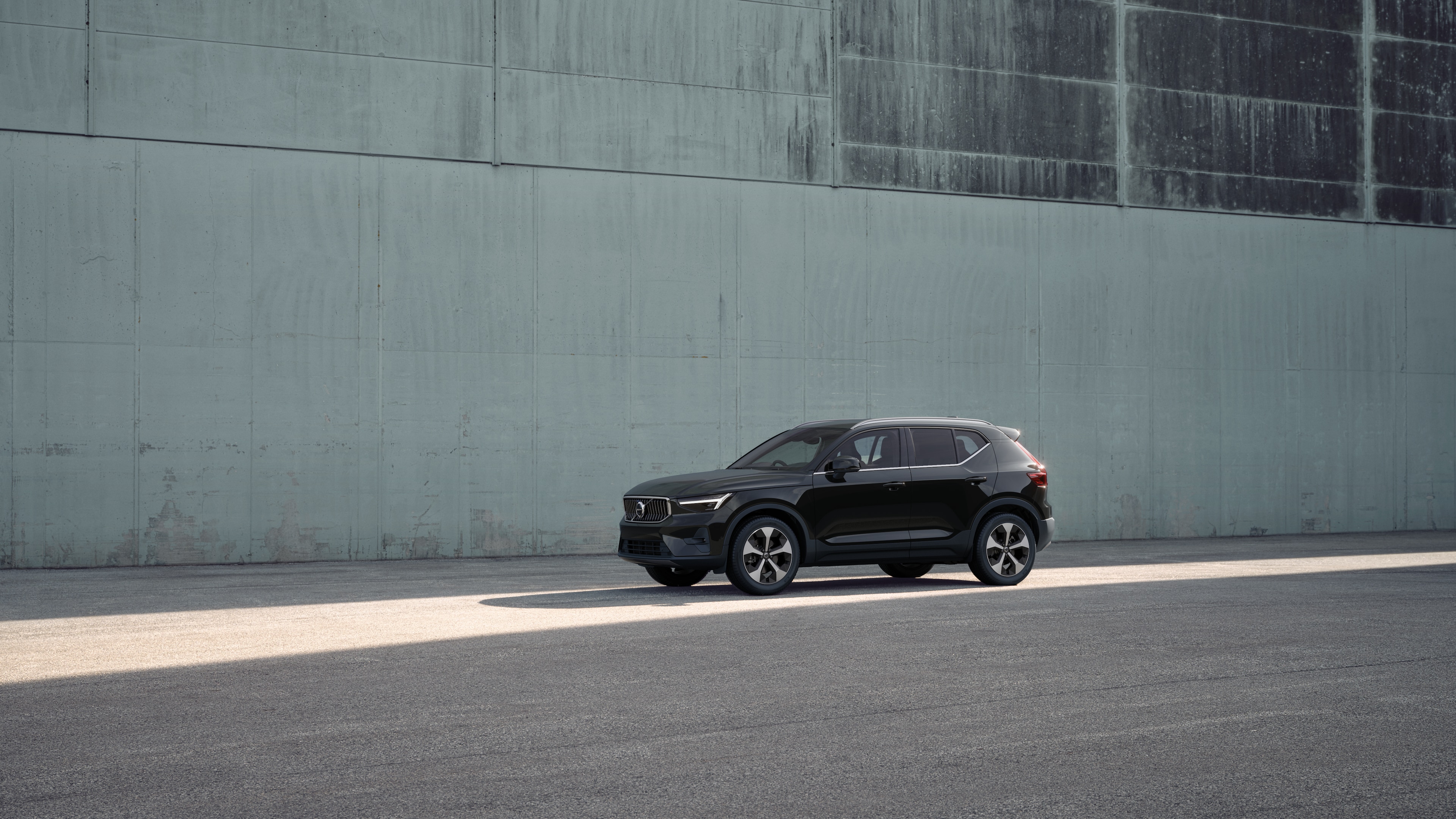 Volvo car exterior in three-quarter view against an industrial concrete wall background.