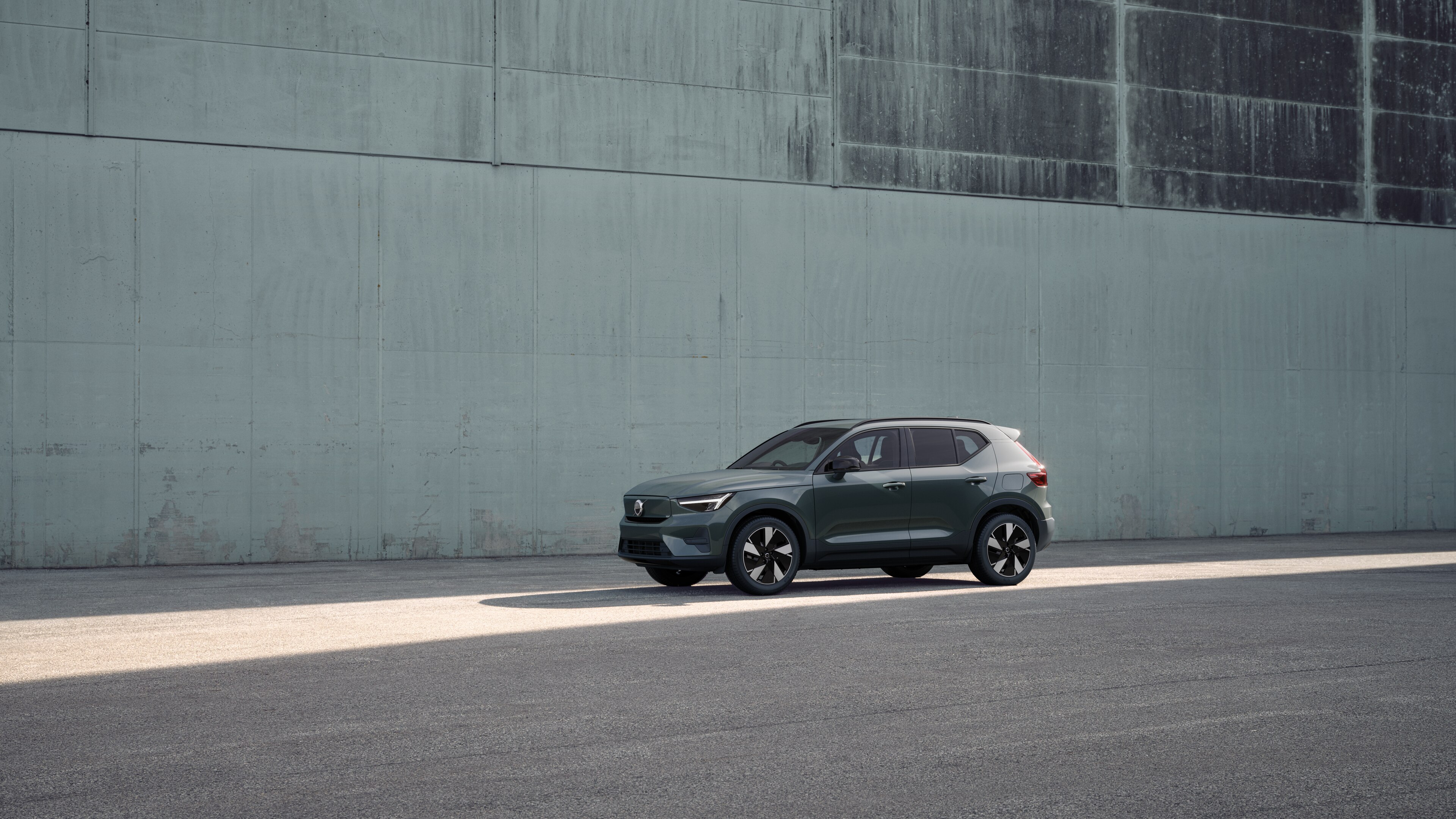 Volvo car exterior in three-quarter view against an industrial concrete wall background.
