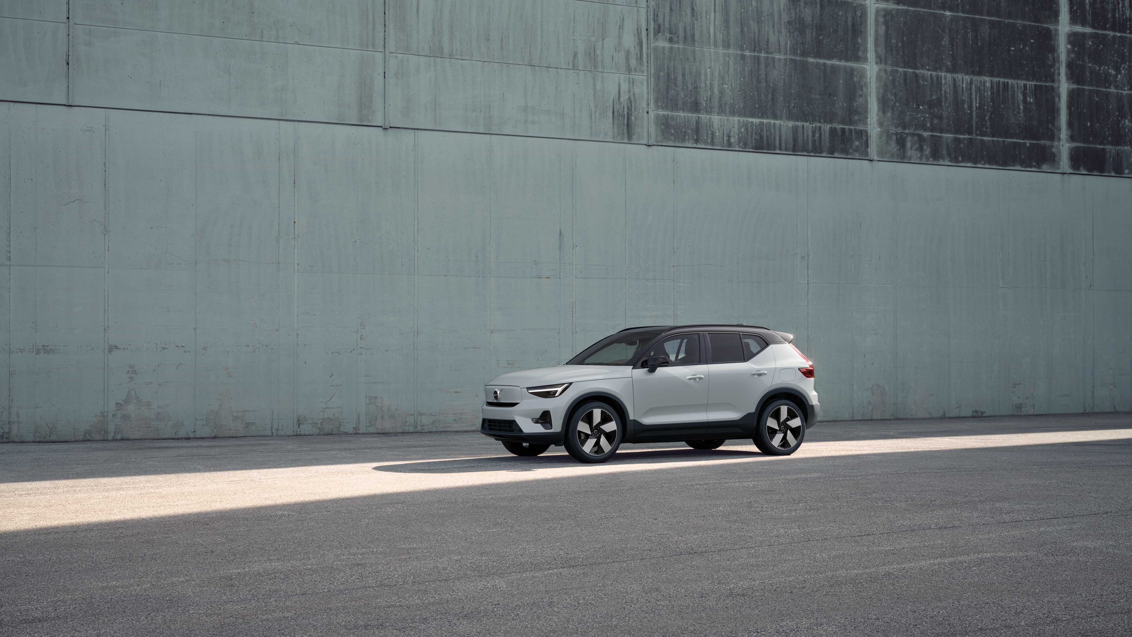 Exterior del vehículo Volvo en vista de tres cuartos sobre un fondo de muro de hormigón industrial.