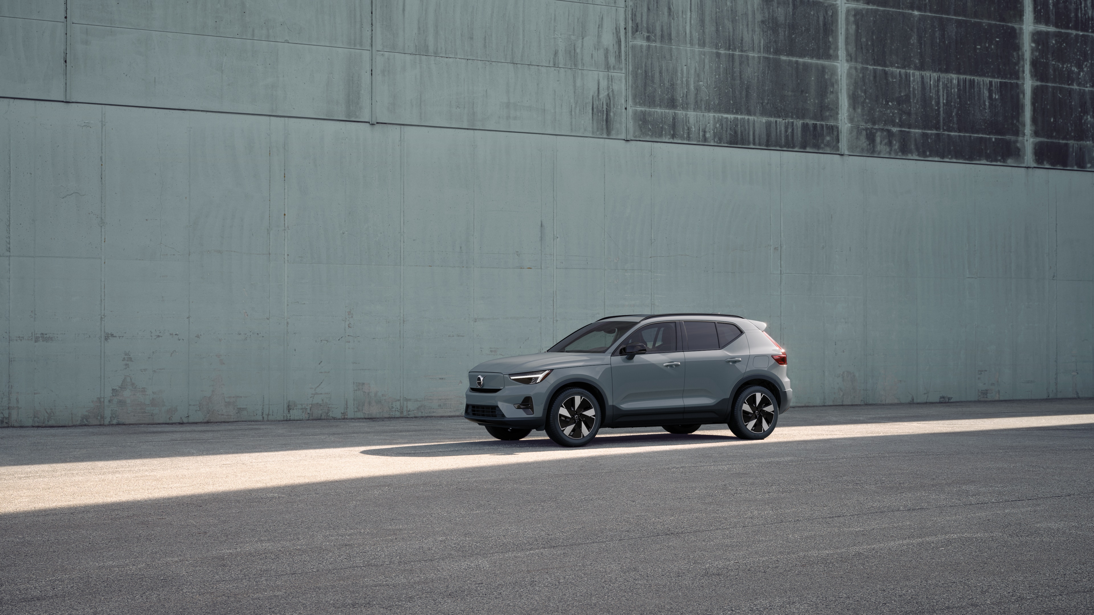 Volvo car exterior in three-quarter view against an industrial concrete wall background.