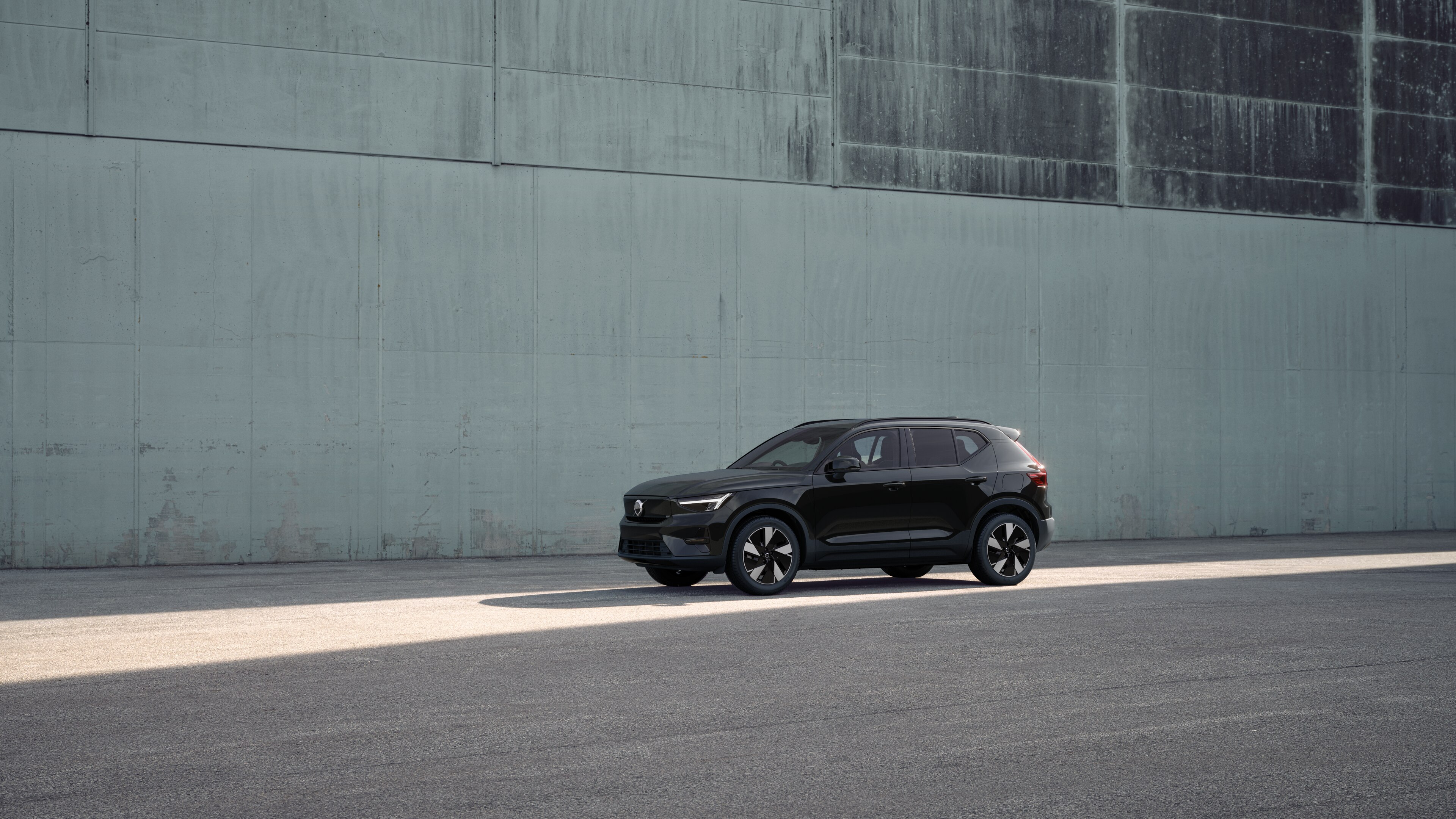 Volvo car exterior in three-quarter view against an industrial concrete wall background.