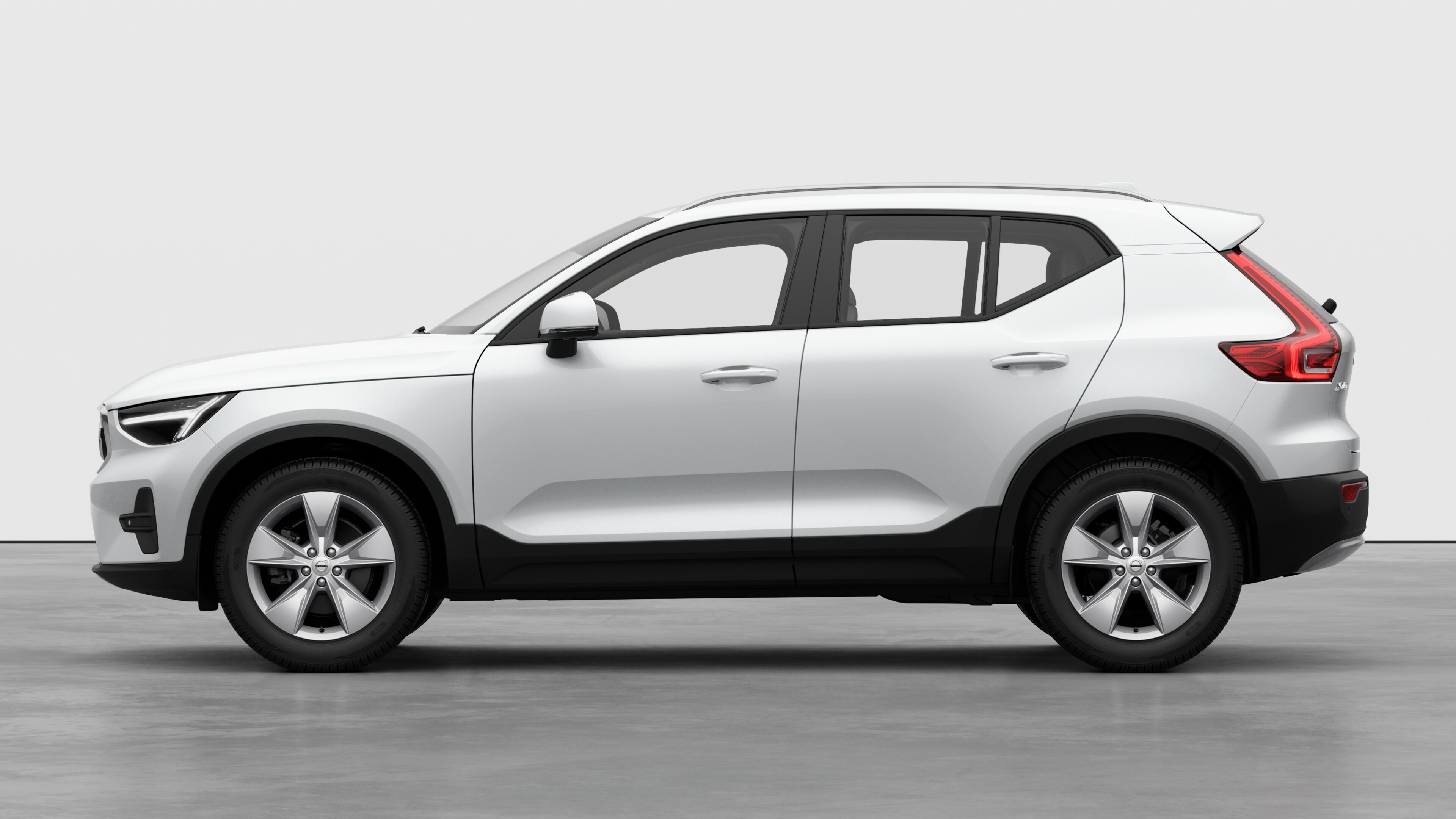 평범한 스튜디오 배경에 볼보 자동차가 옆에서 보입니다. 추가 세부 정보나 식별자가 없습니다.