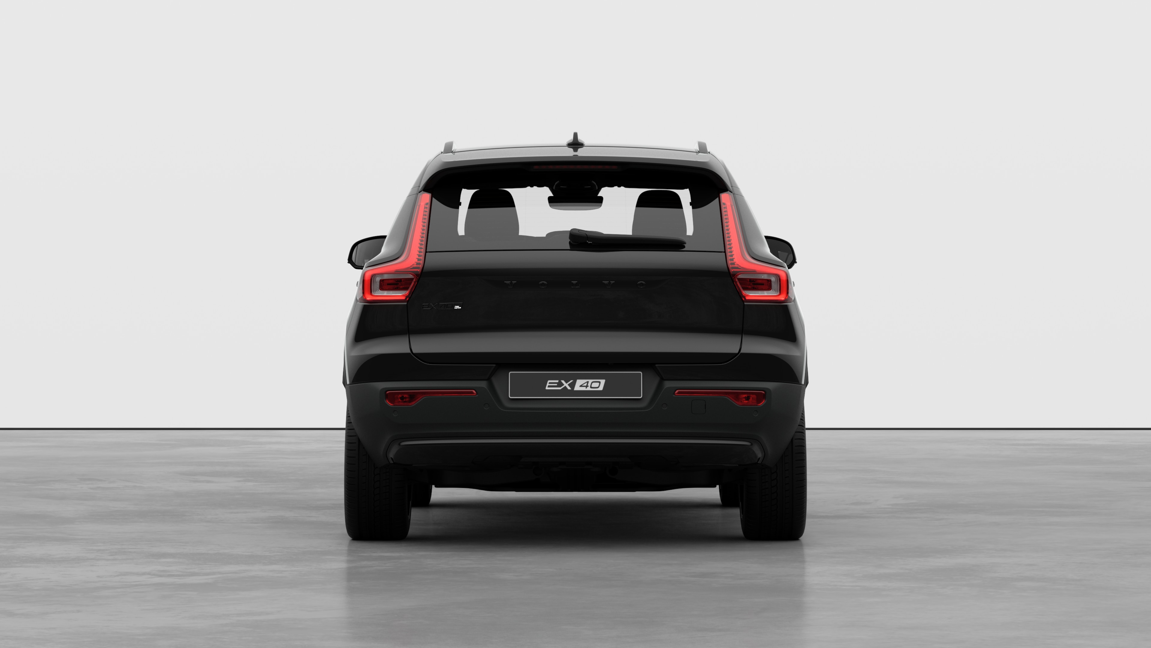 Horft aftan á Volvo-bíl með látlausan stúdíóbakgrunn.