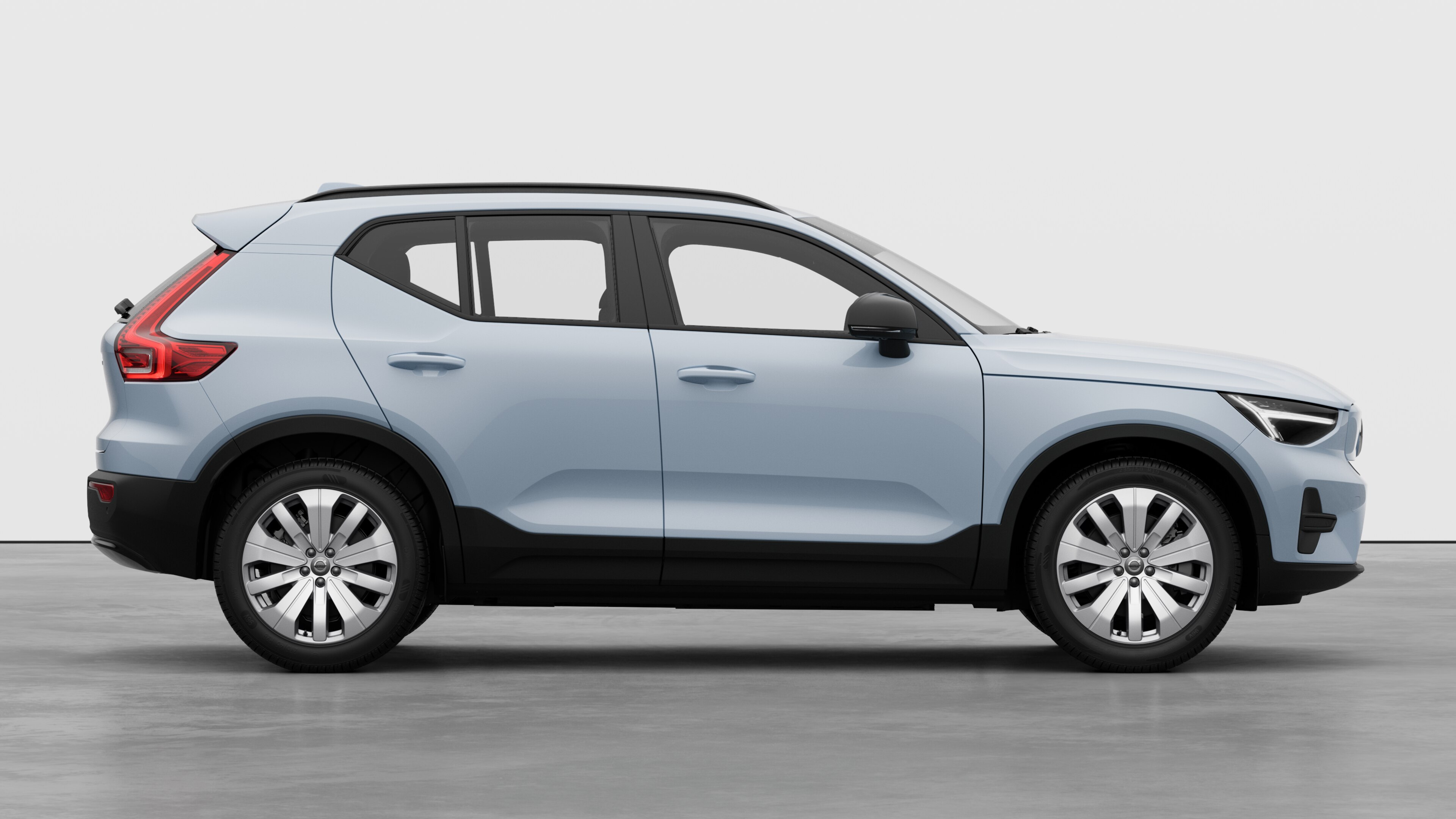Vista laterale di un'auto Volvo sullo sfondo di uno studio che mostra le portiere chiuse e il design visibile delle ruote.