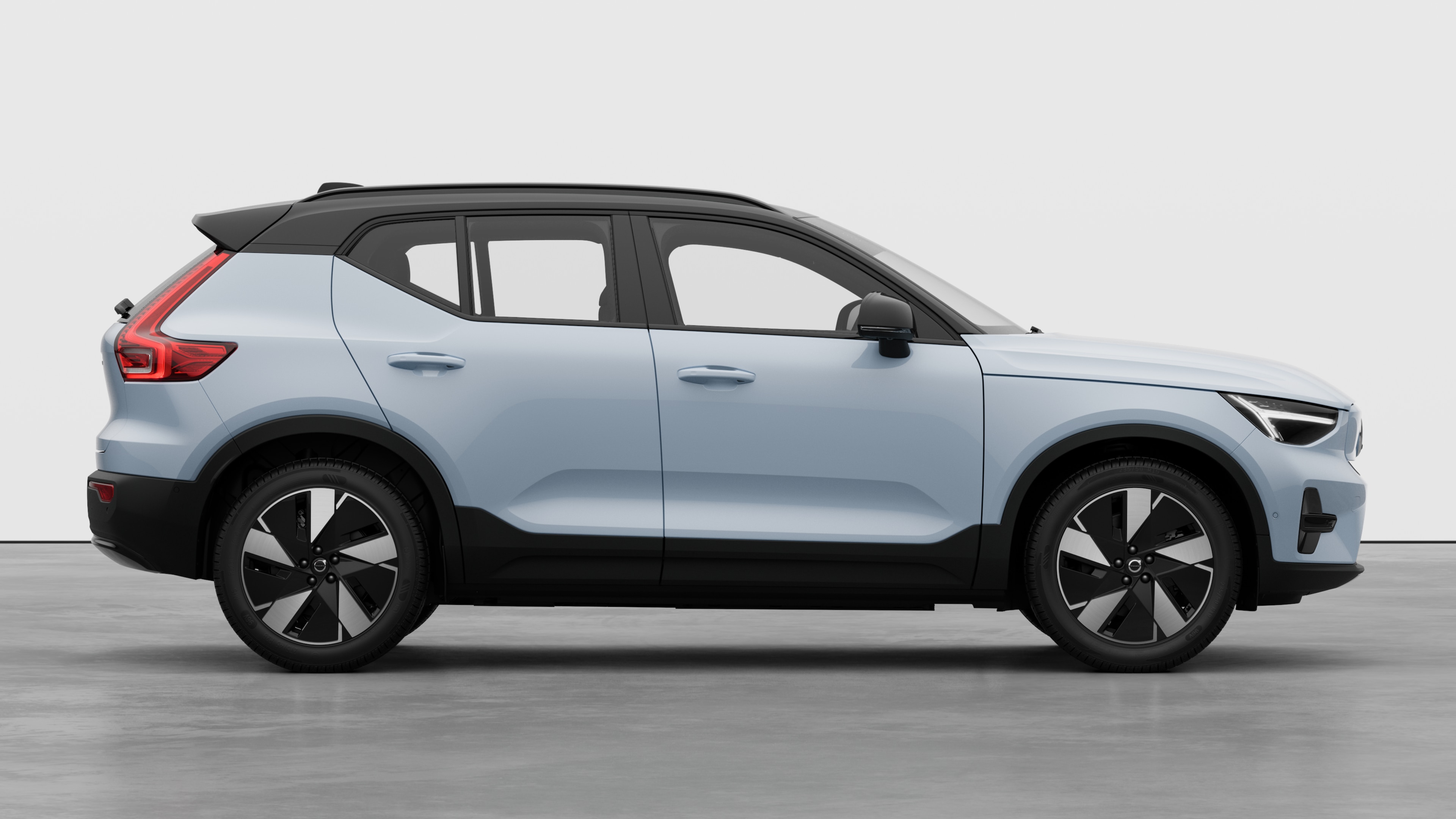 Volvo car side view on plain studio background displaying closed doors and visible wheel design.