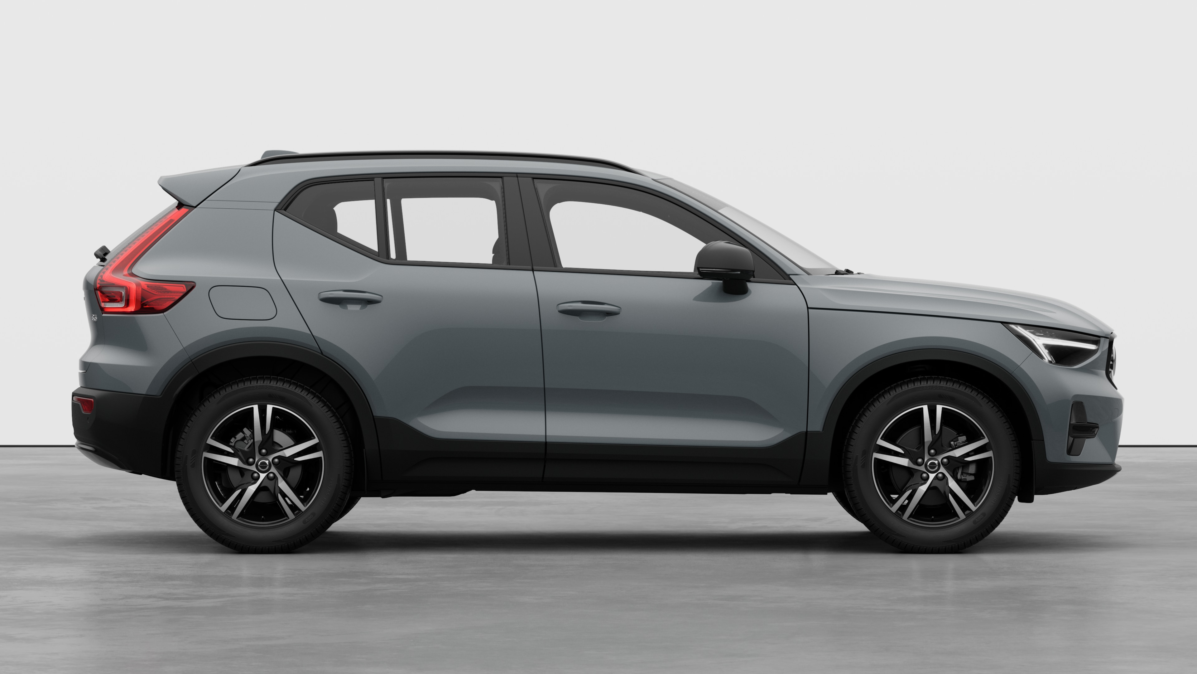 Vue latérale d’une Volvo sur fond de studio montrant les portes fermées et le design des roues visible.