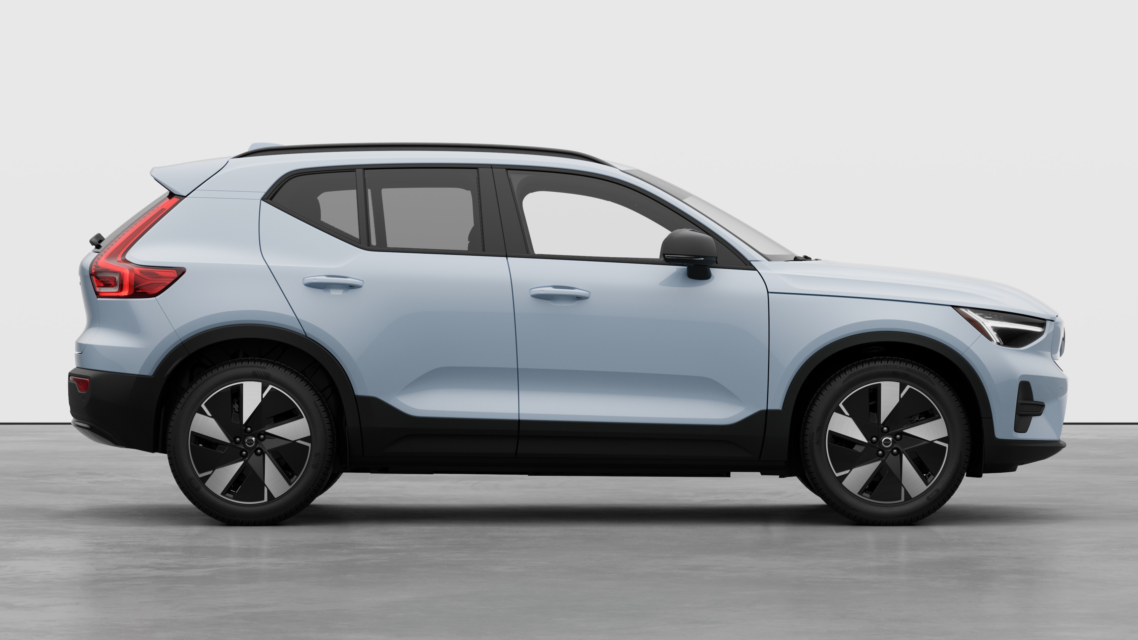 Volvo car side view on plain studio background displaying closed doors and visible wheel design.