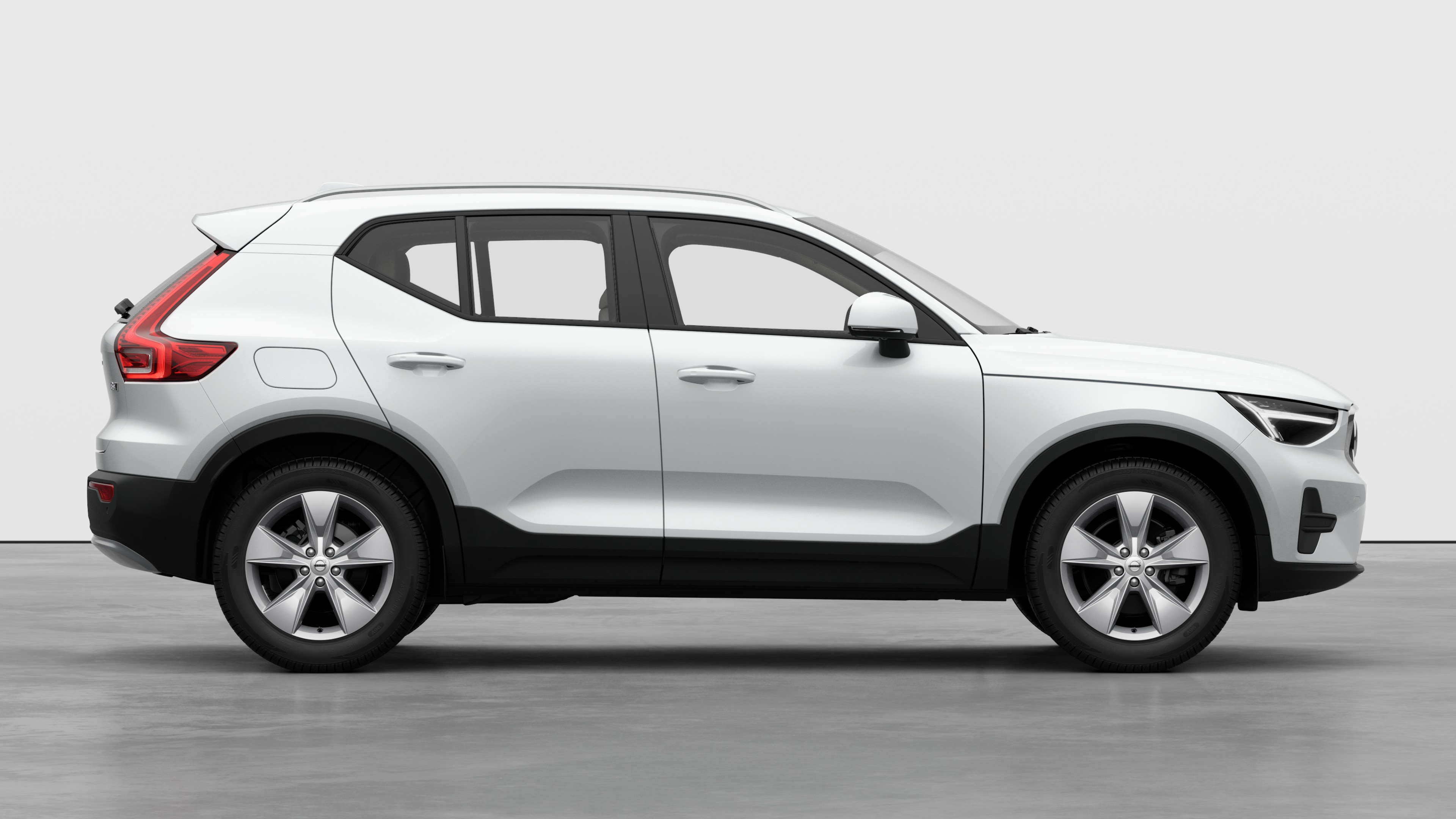 닫힌 문과 눈에 띄는 바퀴 디자인을 표시하는 평범한 스튜디오 배경에 볼보 자동차 측면도.