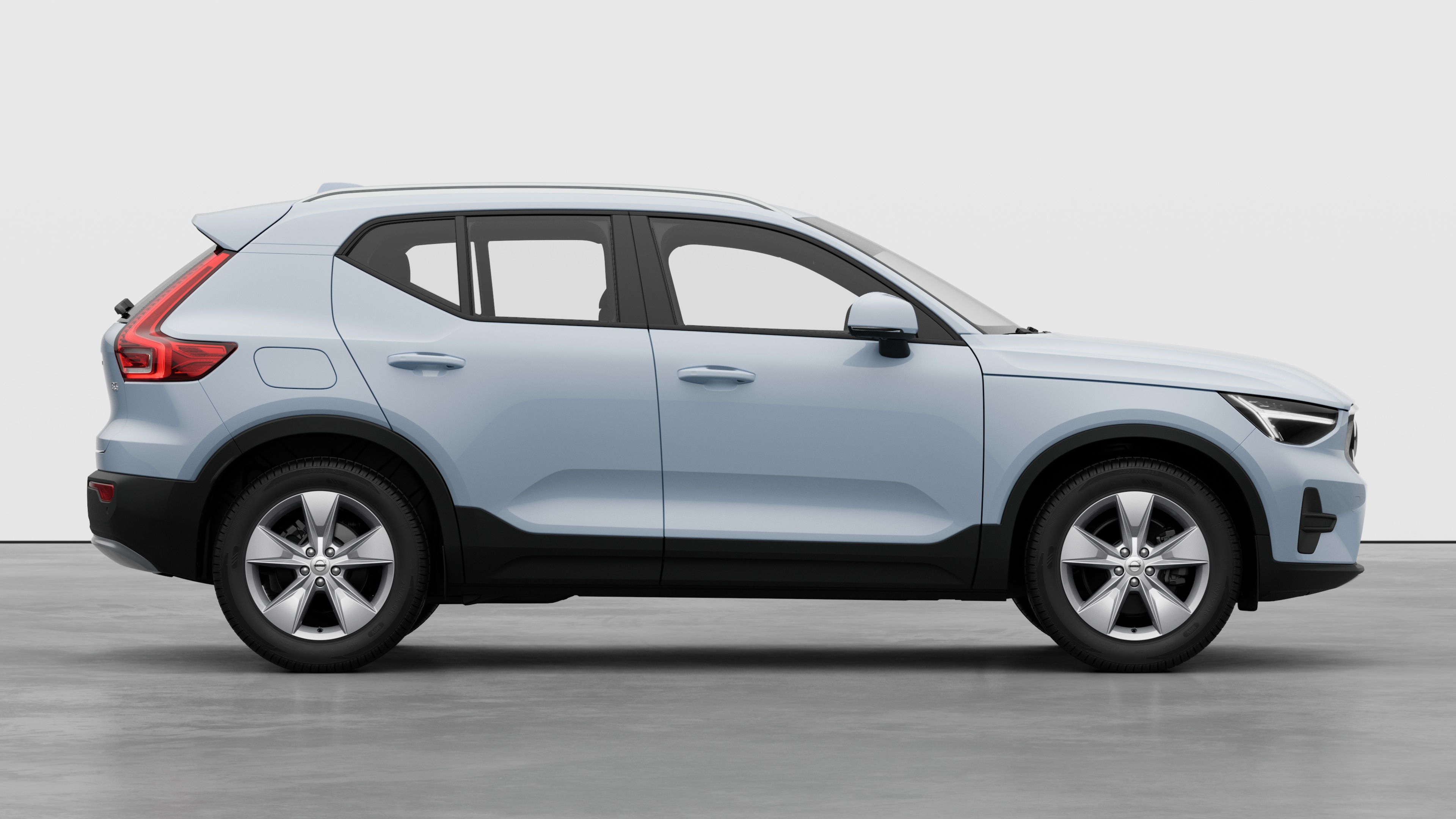 Vue latérale d’une Volvo sur un fond de studio uni, montrant les portes fermées et le design des roues visibles.