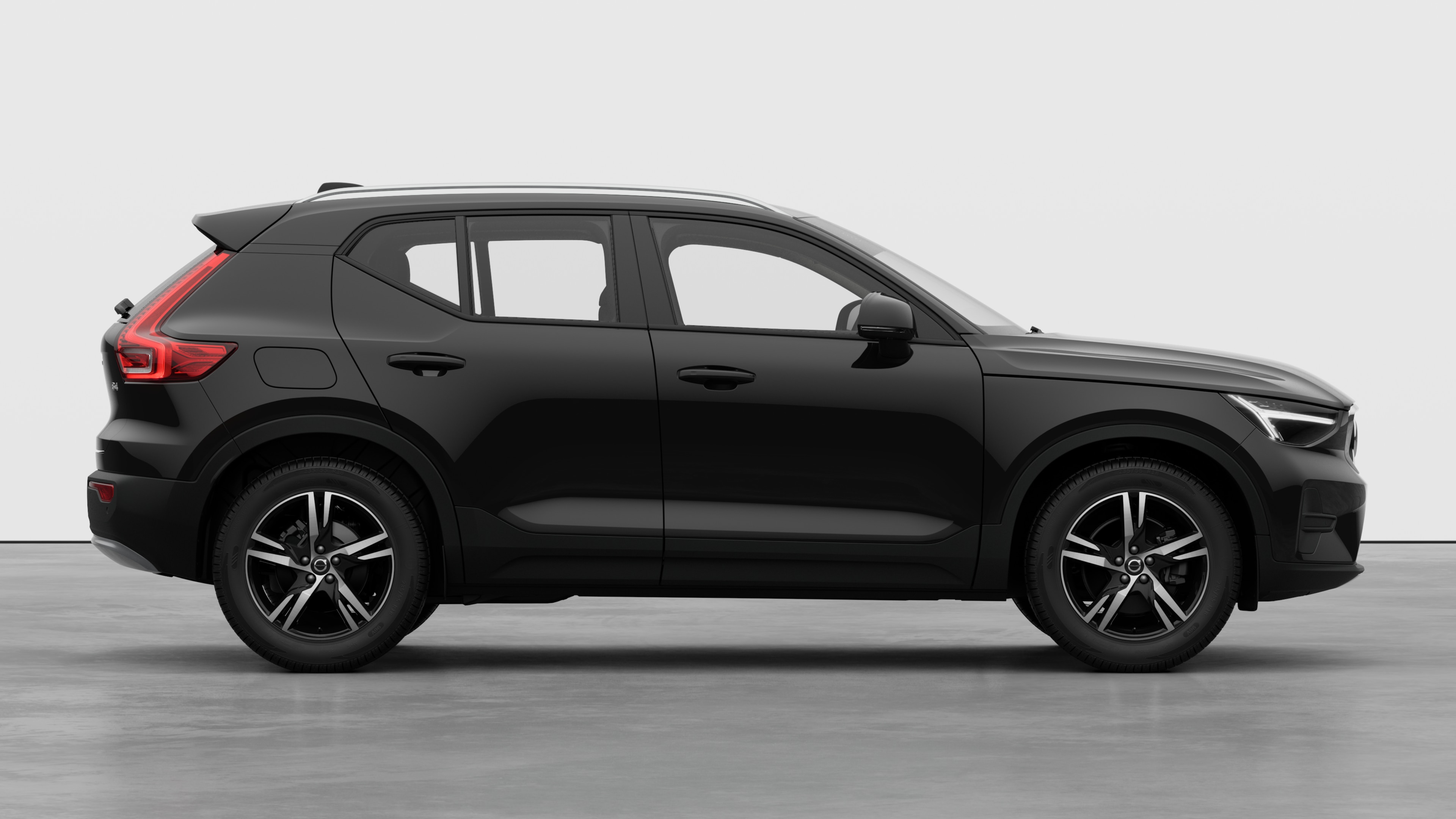 Volvo car side view on plain studio background displaying closed doors and visible wheel design.